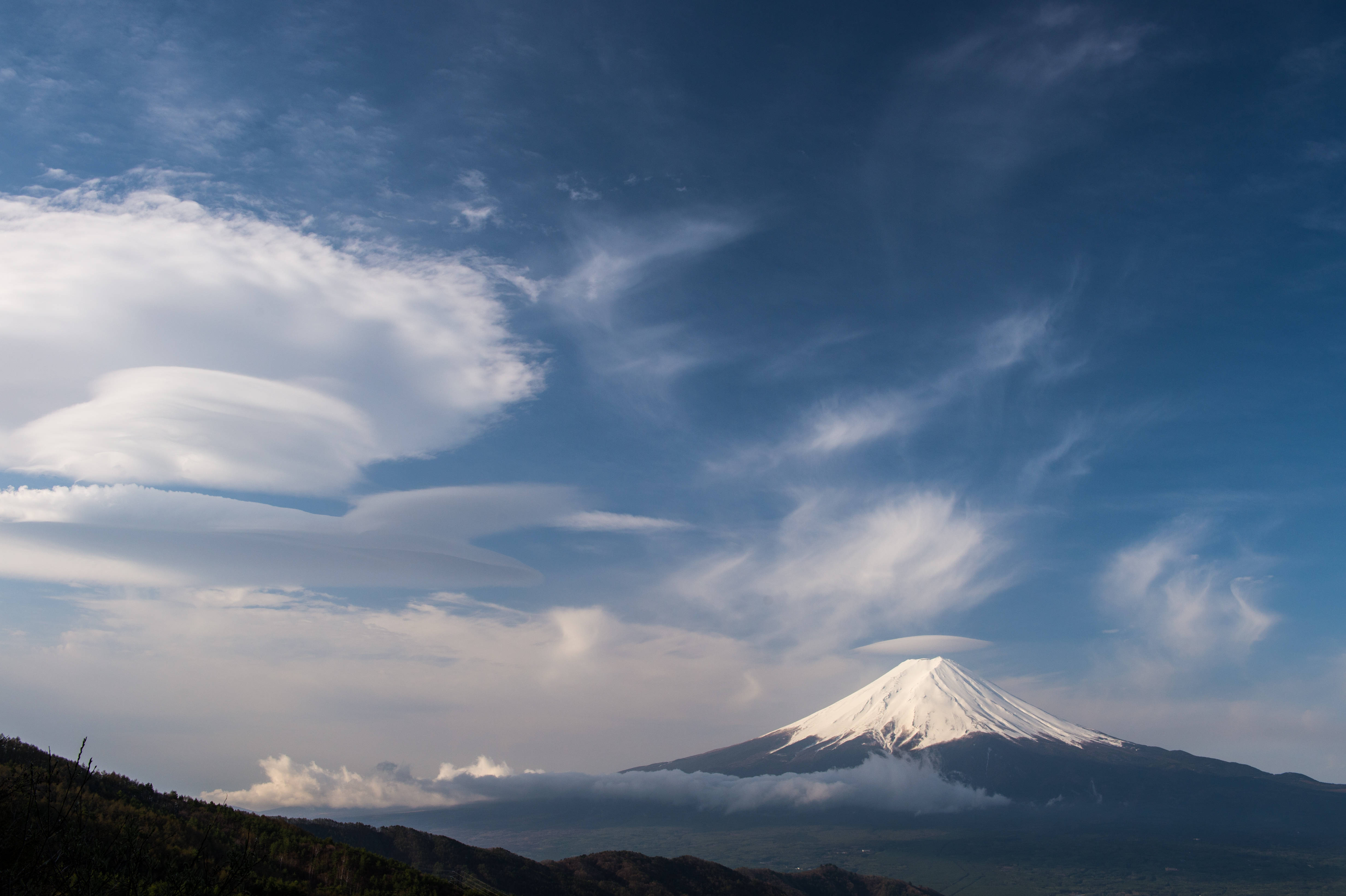 富士山 桌布 壁紙 — 白雪覆蓋的富士山在廣闊的藍天下雄偉地聳立，天空點綴著戲劇性的透鏡狀雲。