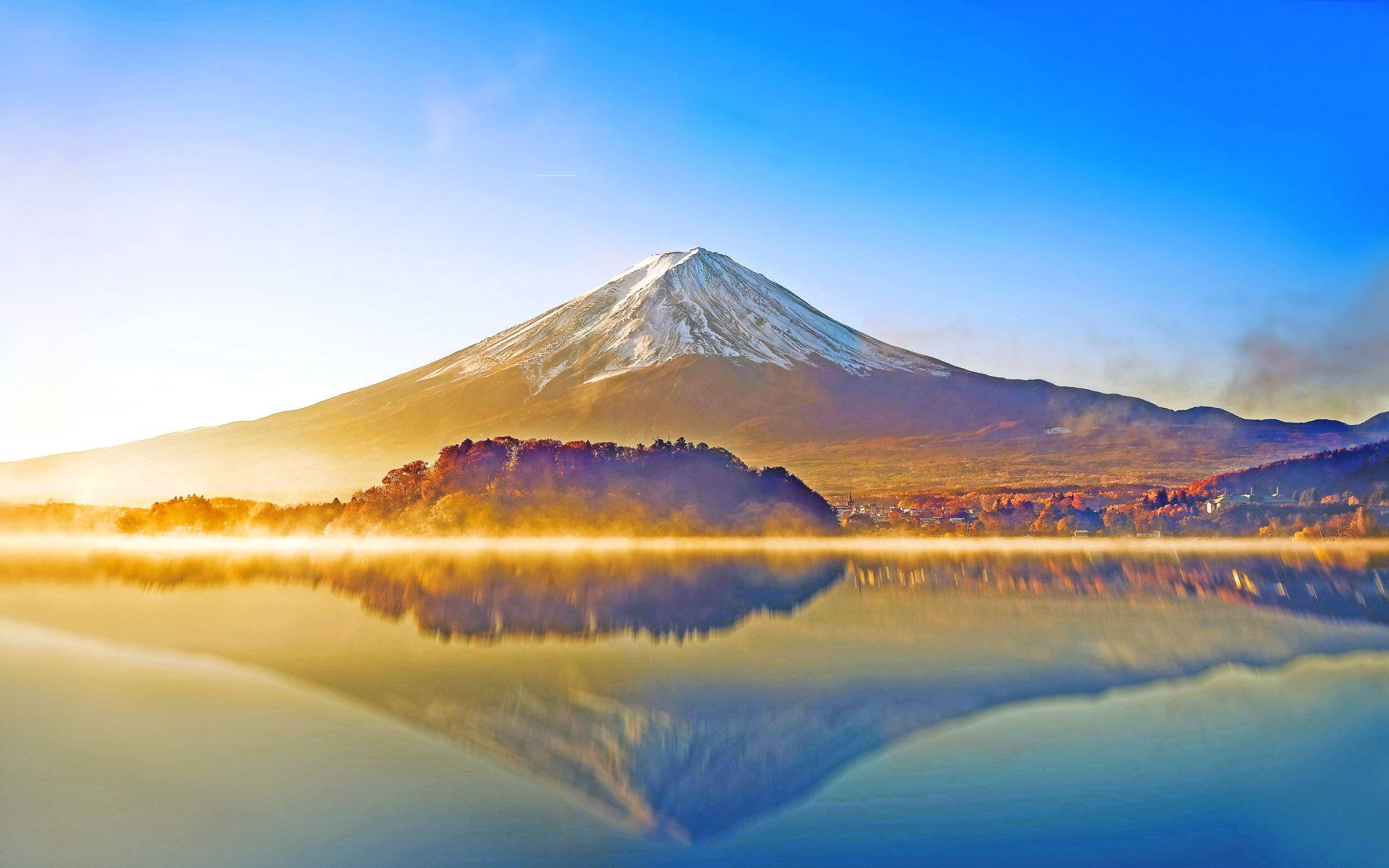 富士山 桌布 壁紙 — 白雪覆蓋的富士山在日出時分雄偉地聳立在霧氣繚繞的湖面上，完美倒影與秋葉相映成趣。