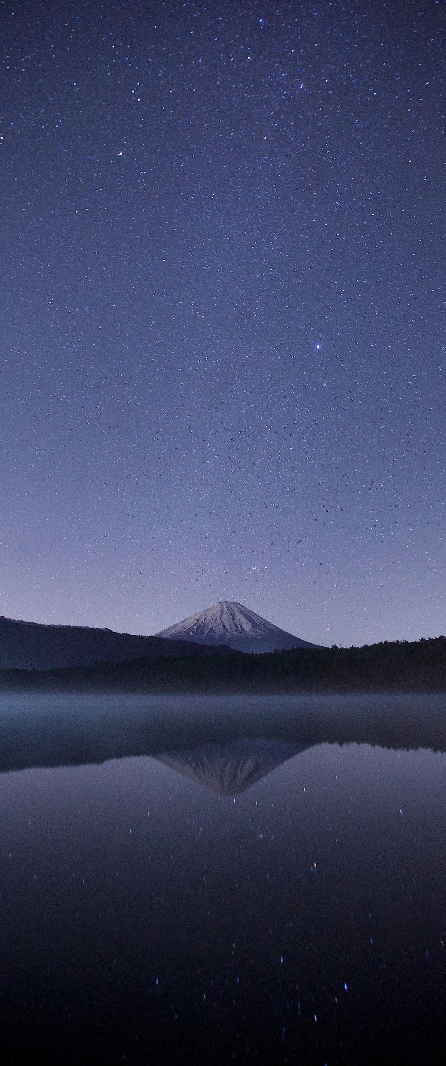 直式 桌布 壁紙 — 白雪覆蓋的富士山在星空下完美倒映在霧氣瀰漫的湖面上。