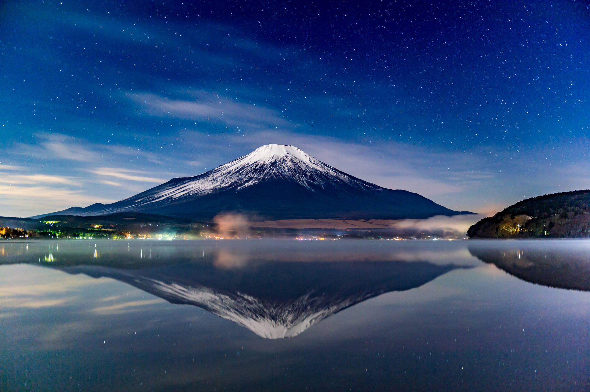 富士山 桌布 壁紙 — 白雪覆蓋的富士山在星空下完美倒映在霧氣繚繞的湖中，下方城市燈光閃爍。