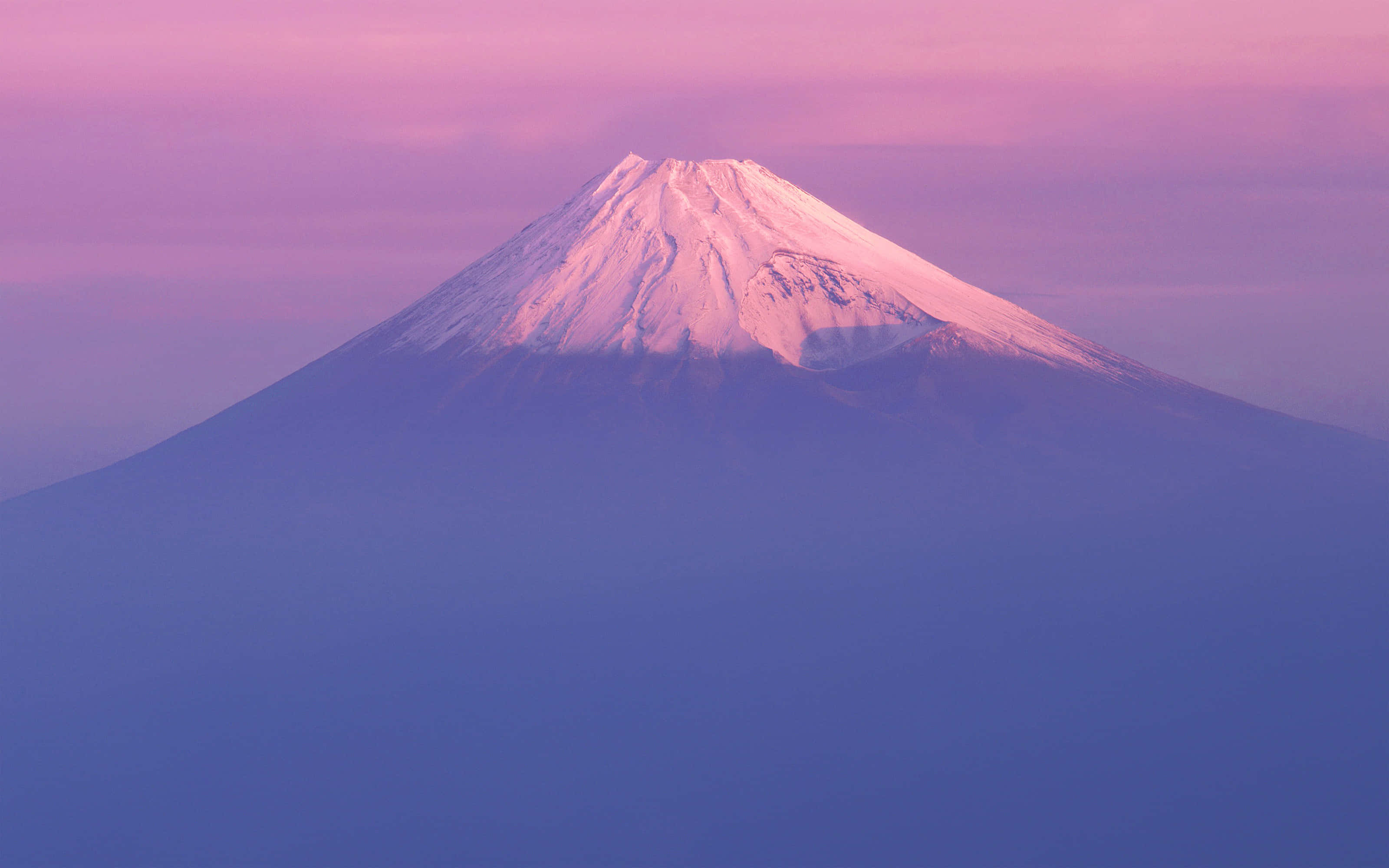 山景 桌布 壁紙 — 白雪覆蓋的富士山在暮色天空下，伴隨著柔和漸變的雲彩，散發出粉紅和紫色的光芒。