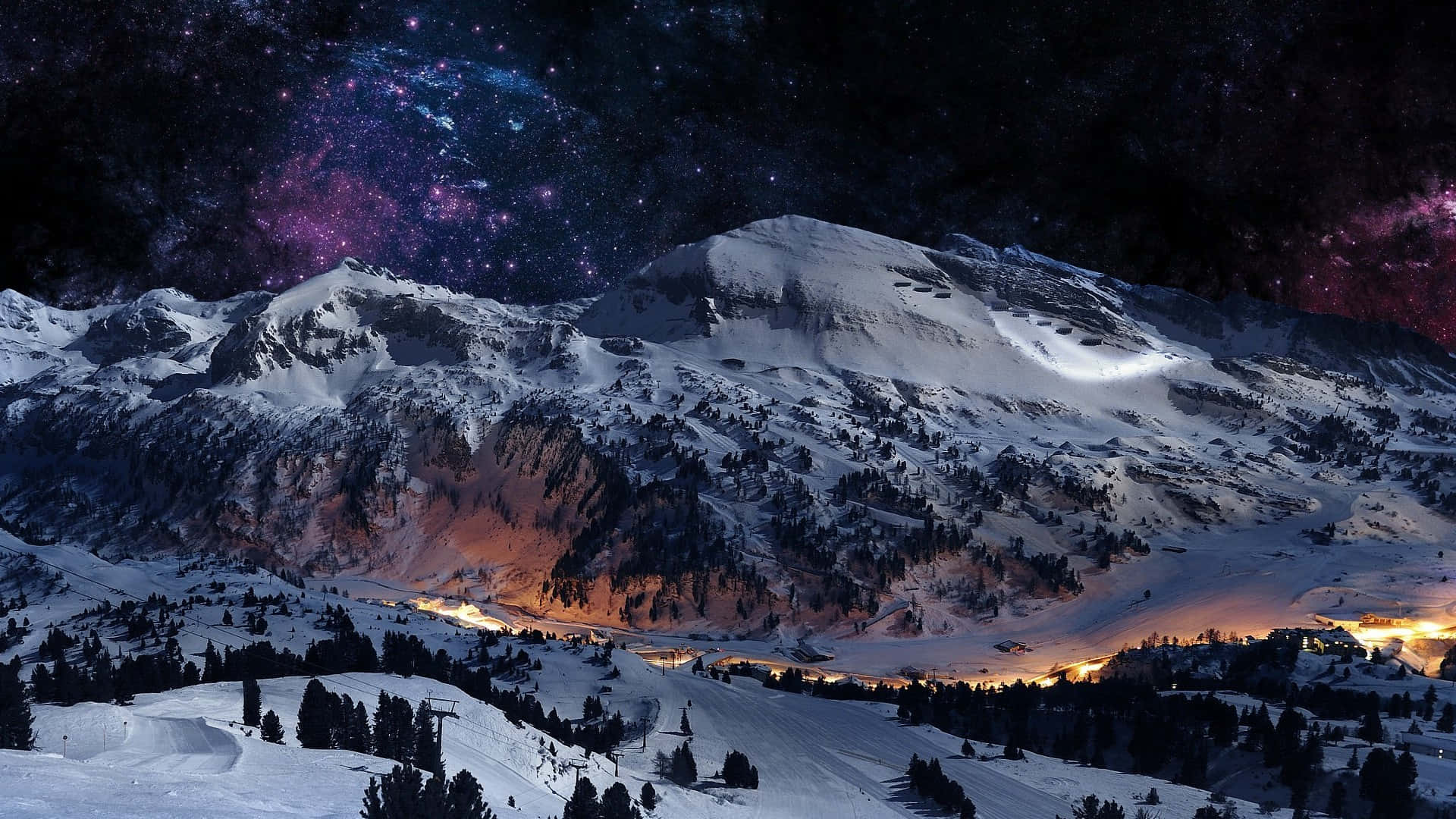 Ski Mountain 桌布 壁紙 — 白雪覆蓋的山峰，下方是璀璨星空下閃爍的山谷燈光。