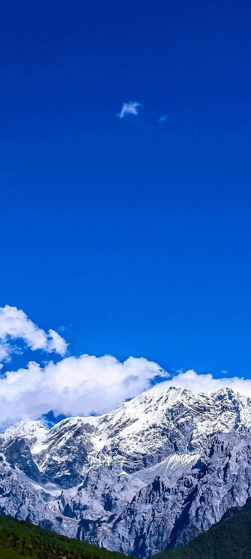在明亮的藍天下，白雪覆蓋的山脈，雲朵散落。 — 三星 S21 Ultra 壁紙