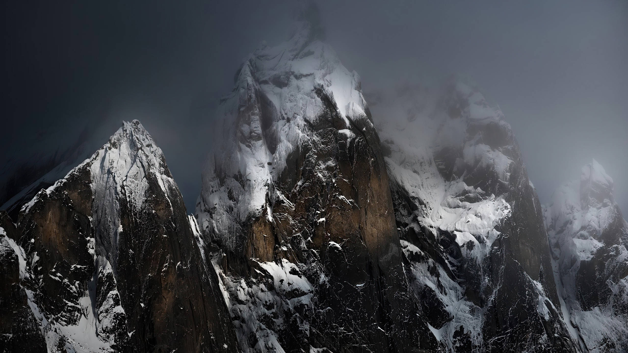 2560x1440 nature 桌布 壁紙 — 白雪覆蓋的山峰刺穿黑暗的暴風雲，形成戲劇性的高海拔景觀。