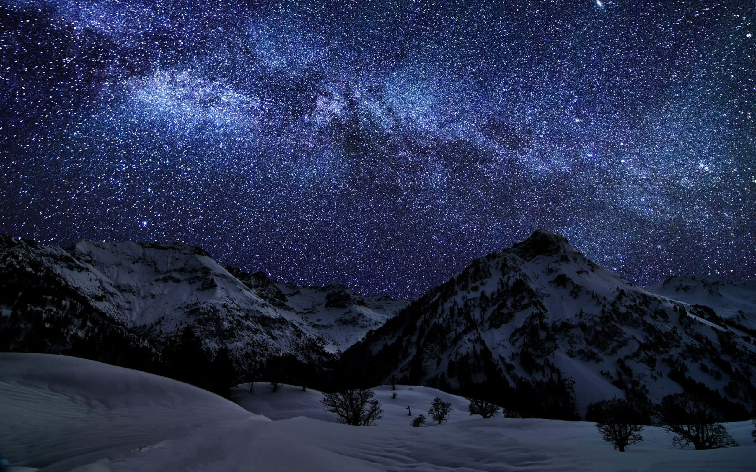 夜空 桌布 壁紙 — 白雪覆蓋的山峰在令人嘆為觀止的星空下聳立，星空充滿了銀河系發光的藍白色帶。