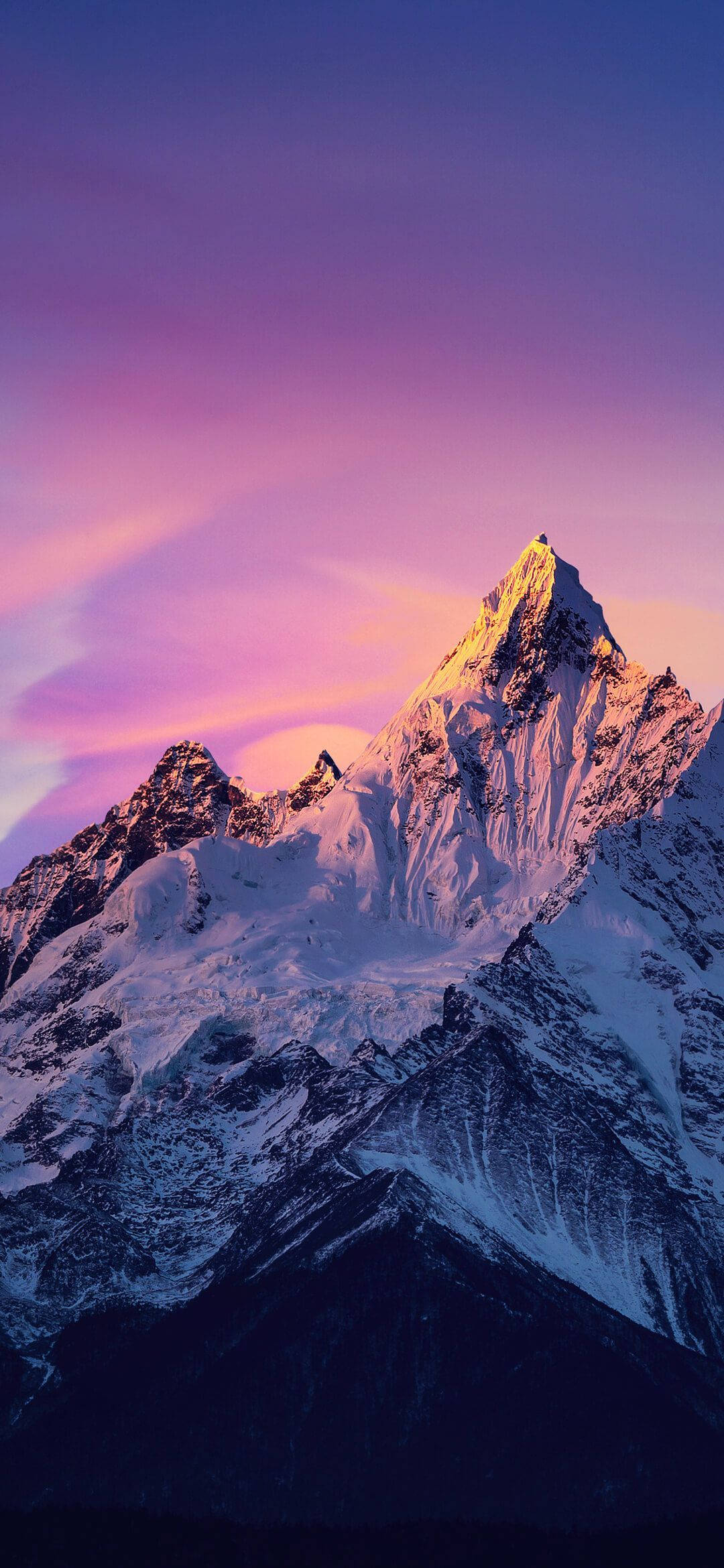 Nepal 桌布 壁紙 — 白雪覆蓋的山峰在充滿活力的紫色和粉紅色暮色天空下閃耀著金色光芒。
