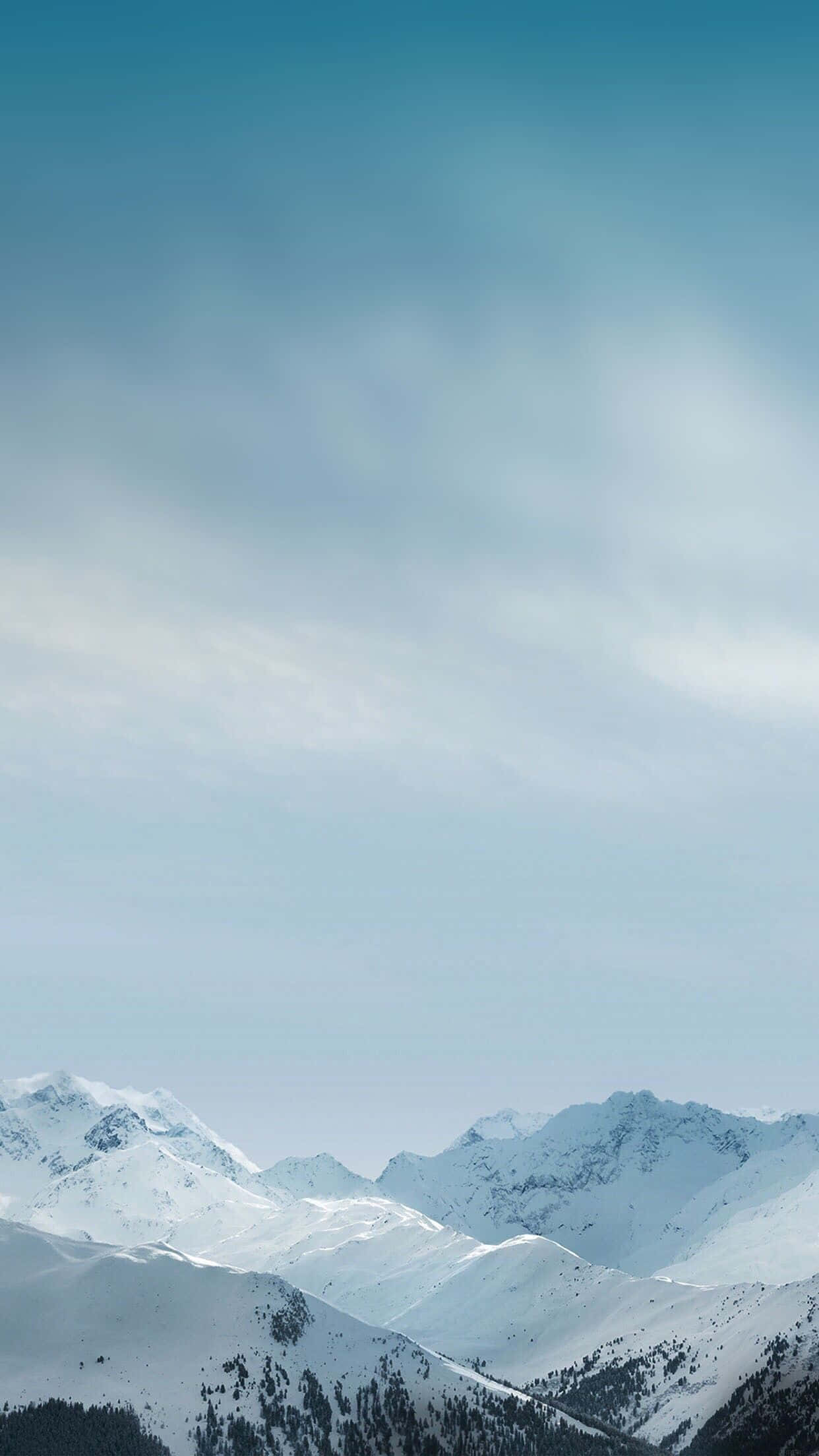Calm Aesthetic 桌布 壁紙 — 白雪覆蓋的山峰在廣闊的淡藍色天空下聳立，天空中有縷縷薄雲。
