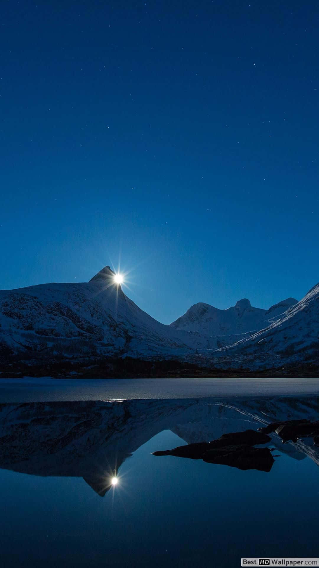 桌布 壁紙 — 白雪覆蓋的山峰在明亮的月光下閃耀，在繁星點點的夜空下，在平靜的冰凍湖面上投射出完美的倒影。