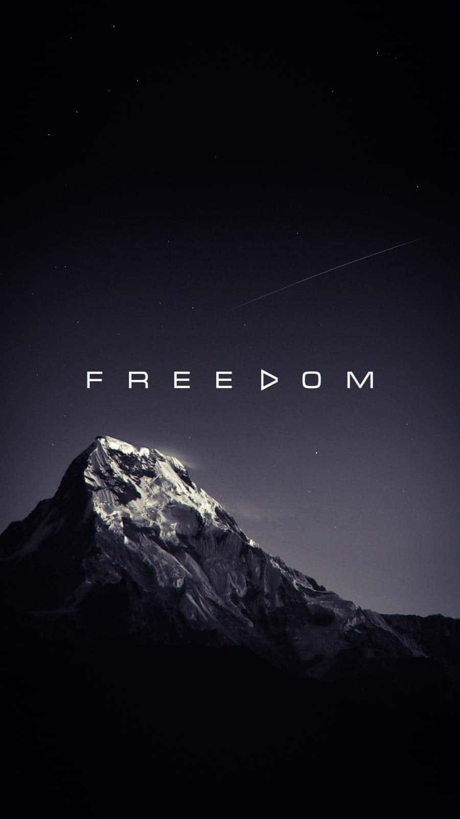 Freedom 桌布 壁紙 — 白雪覆蓋的山峰在星空下聳立，上方閃耀著「自由」二字。