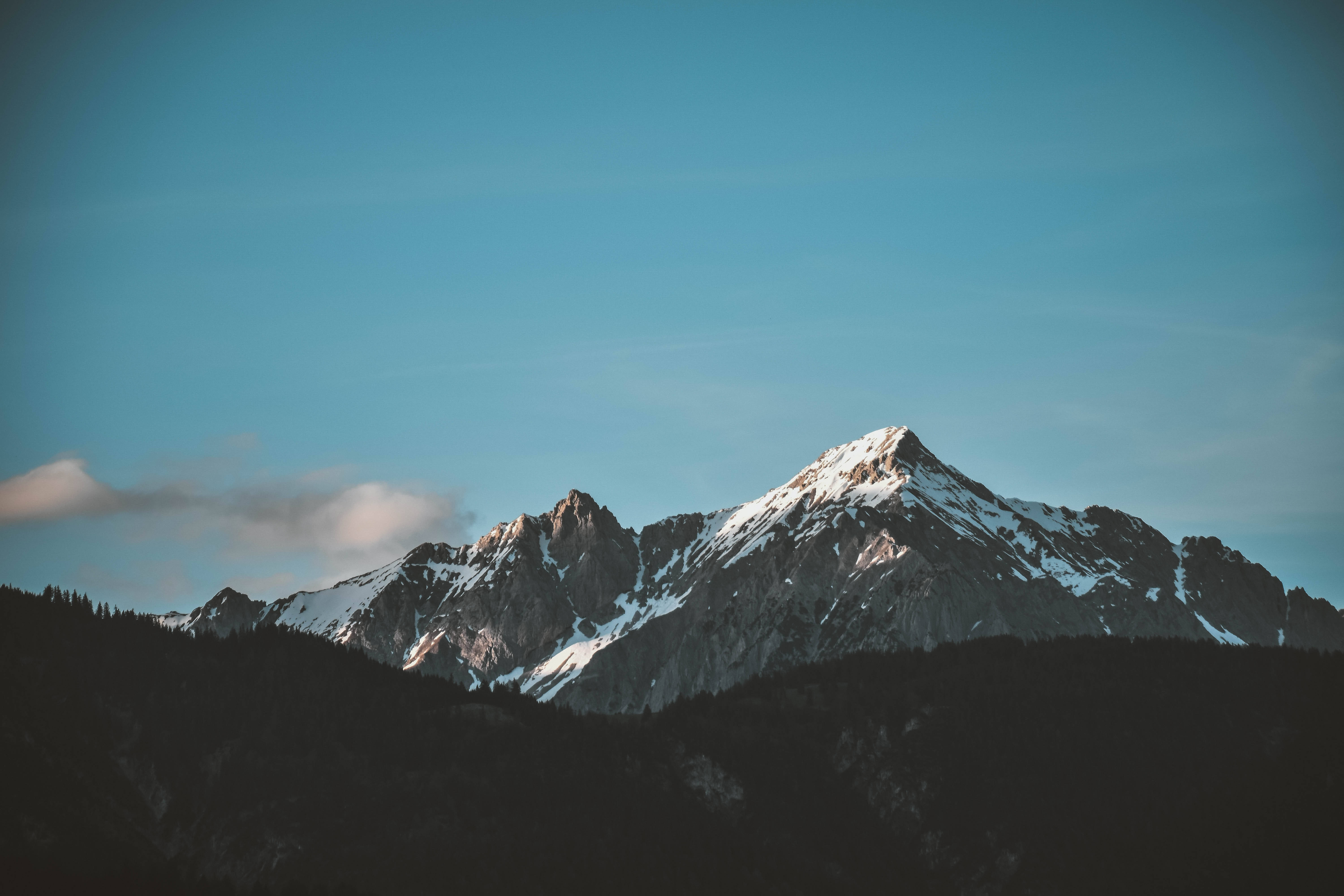 山景 桌布 壁紙 — 白雪覆蓋的山峰在晴朗的藍天和飄浮的柔雲襯托下巍然聳立。