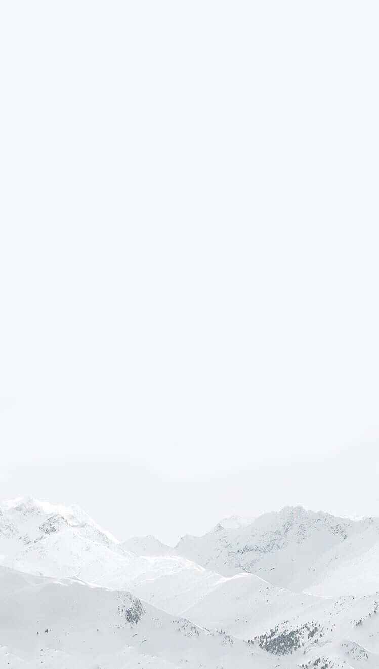 White iPhone 桌布 壁紙 — 白雪覆蓋的山峰在極簡冬季景觀中逐漸融入朦朧的白色天空。
