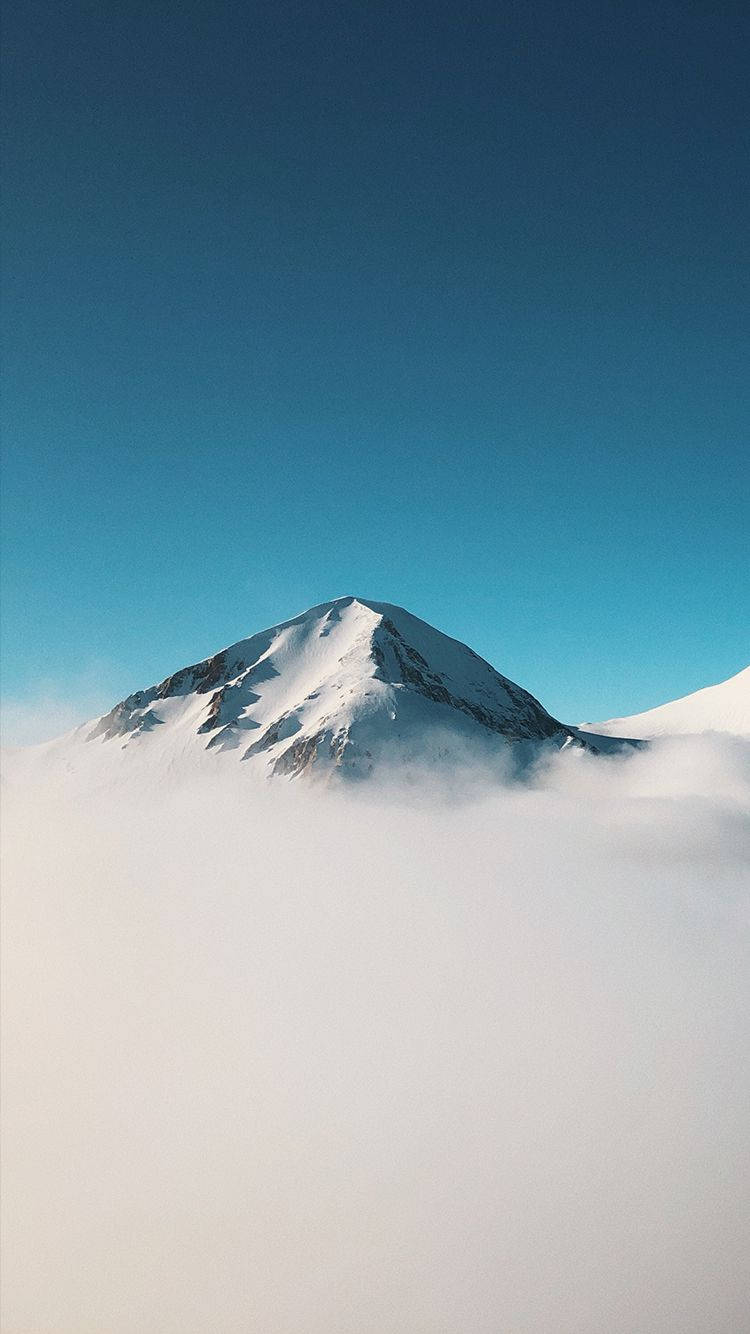 山景 桌布 壁紙 — 白雪覆蓋的山峰在清澈的藍天下穿透厚厚的雲層。