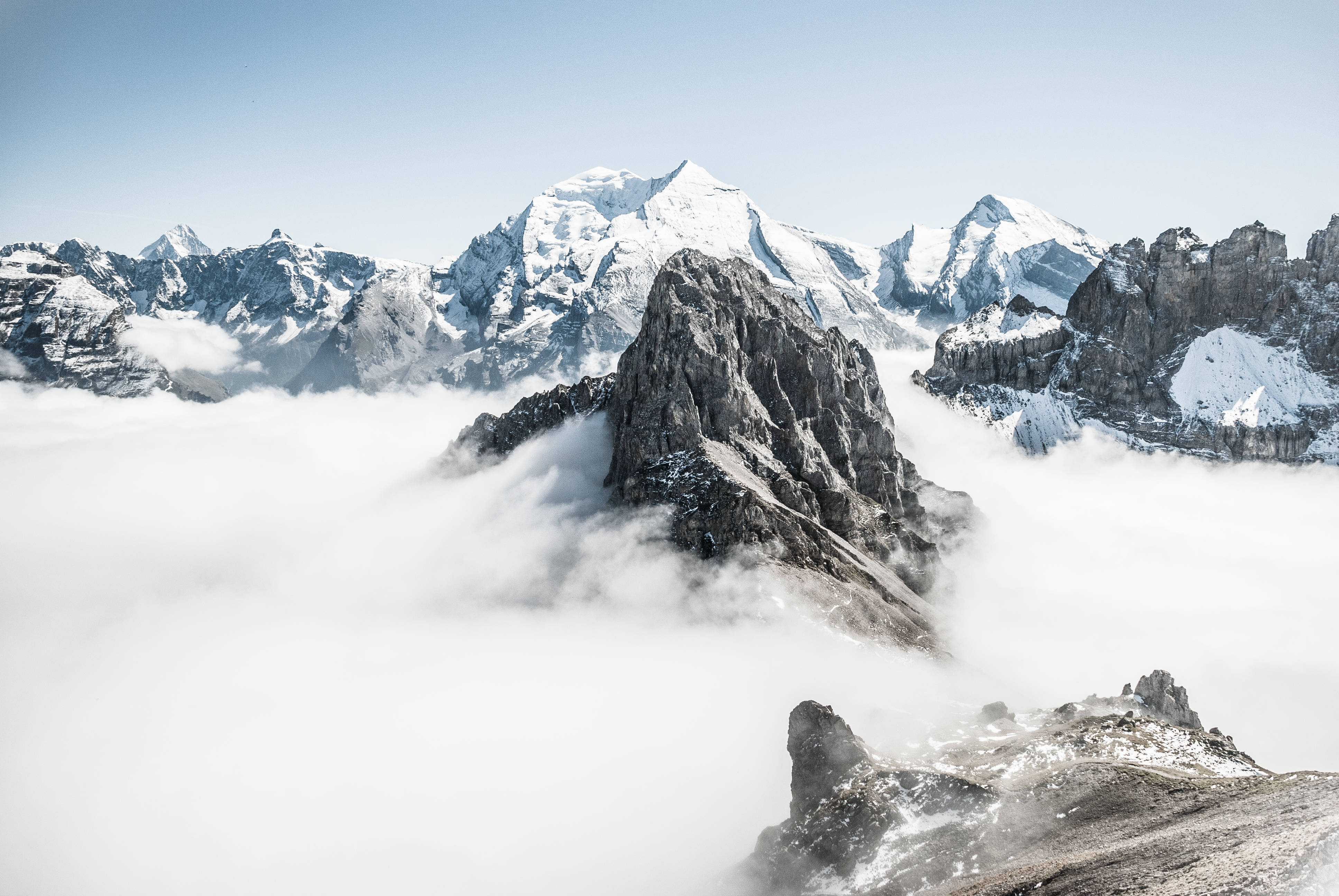 山景 桌布 壁紙 — 白雪覆蓋的山峰在清澈的藍天下穿透厚厚的雲層。