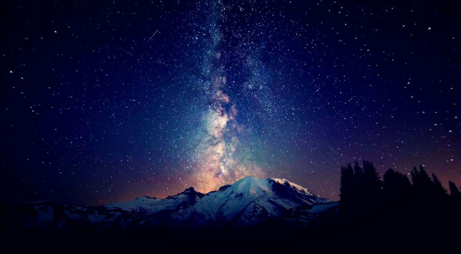 Beautiful Star 桌布 壁紙 — 白雪覆蓋的山峰在燦爛星空夜空襯托下形成剪影，銀河在上方閃耀。