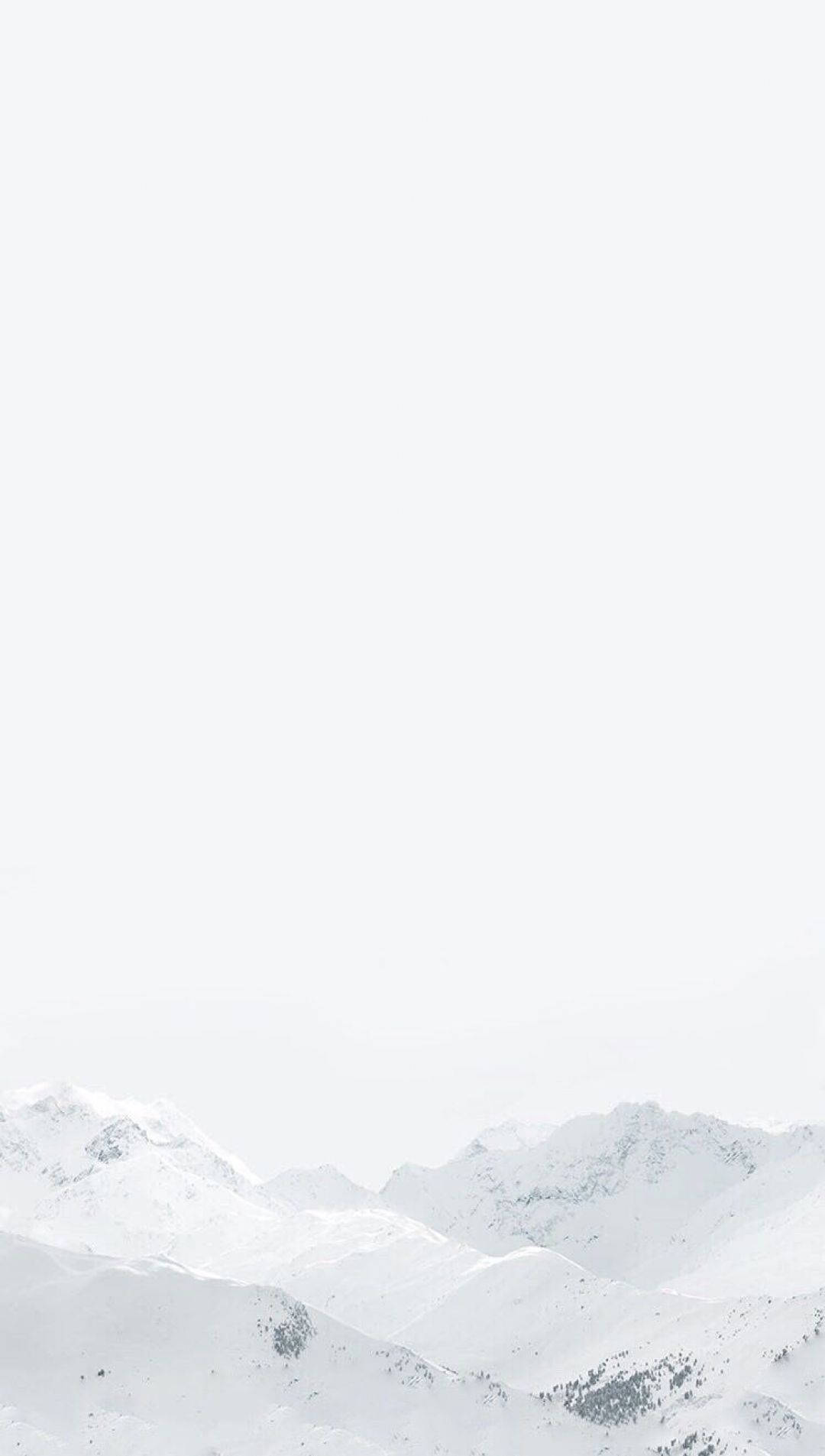  壁紙 — 白雪覆蓋的山峰從朦朧的白色天空中浮現，形成極簡的冬季景觀。