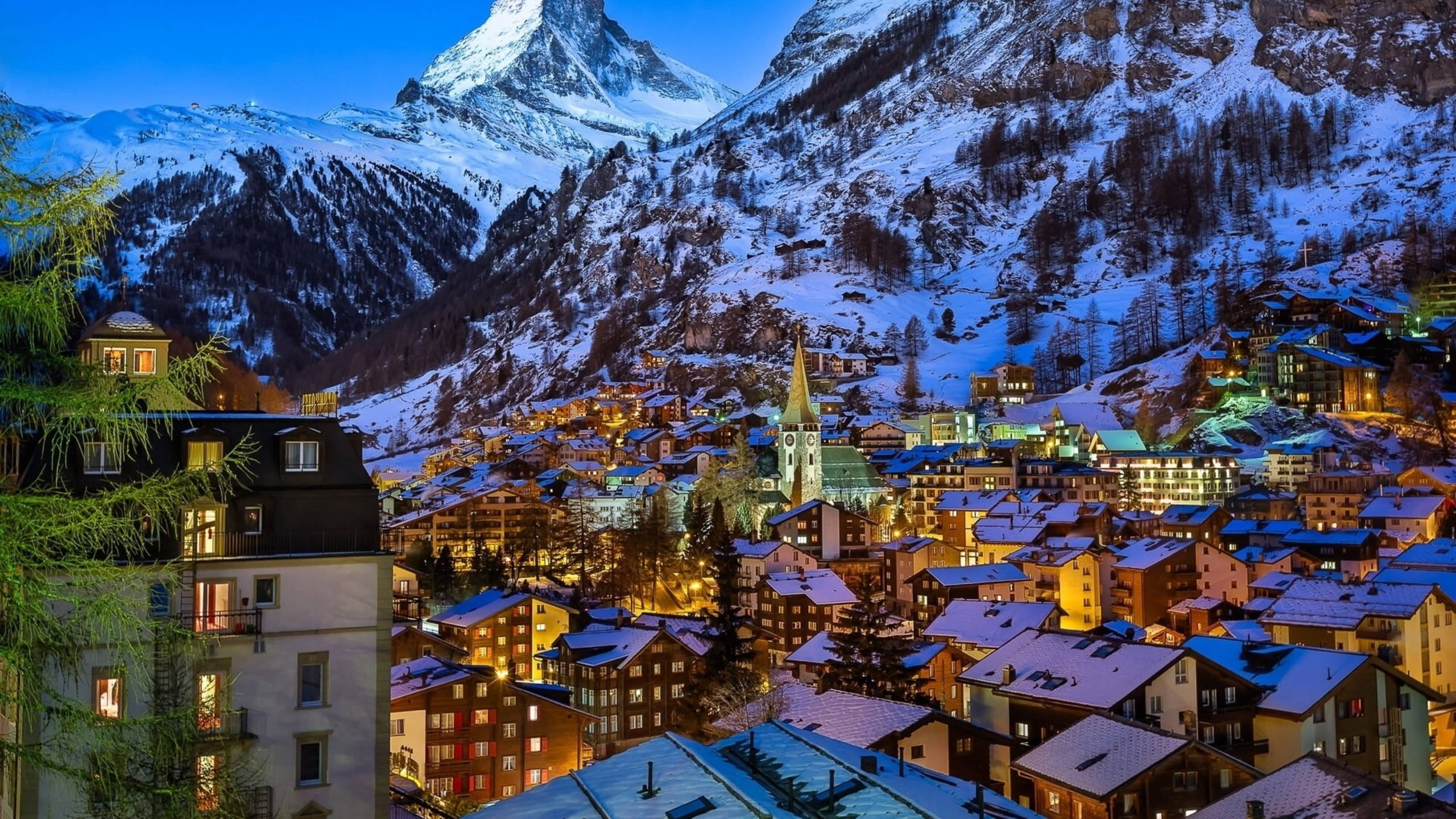 瑞士 桌布 壁紙 — 白雪覆蓋的山村在暮色中，在馬特洪峰高聳的山峰下閃爍著溫暖的燈光。