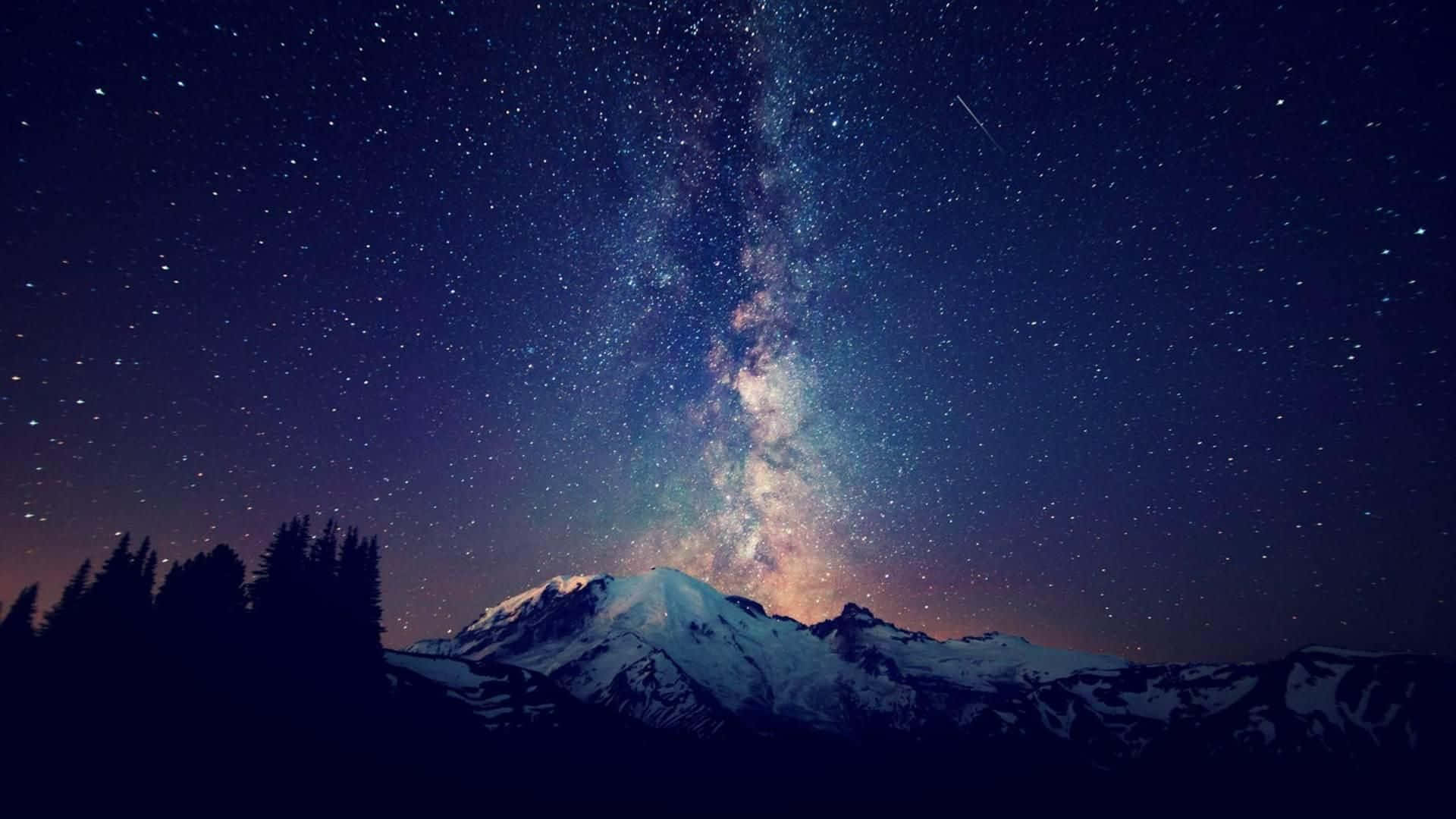 Stars Computer 桌布 壁紙 — 白雪覆蓋的山脈在燦爛星空和銀河閃耀的夜空下形成剪影。