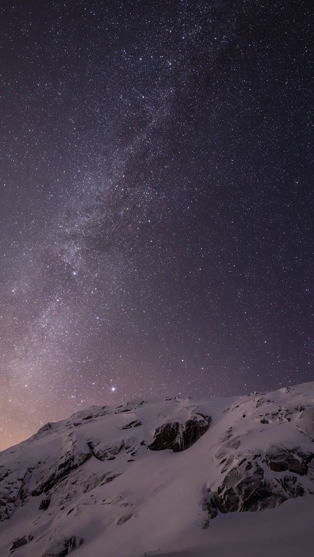 iOS 8 桌布 壁紙 — 白雪覆蓋的山脊，上方是充滿活力的星空，銀河拱跨天際。