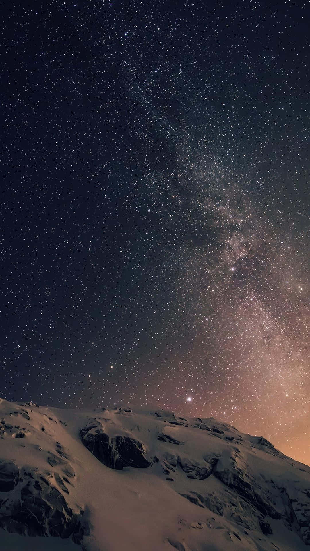 桌布 壁紙 — 白雪覆蓋的山脊，在令人嘆為觀止的星空下，銀河以溫暖色調閃耀。