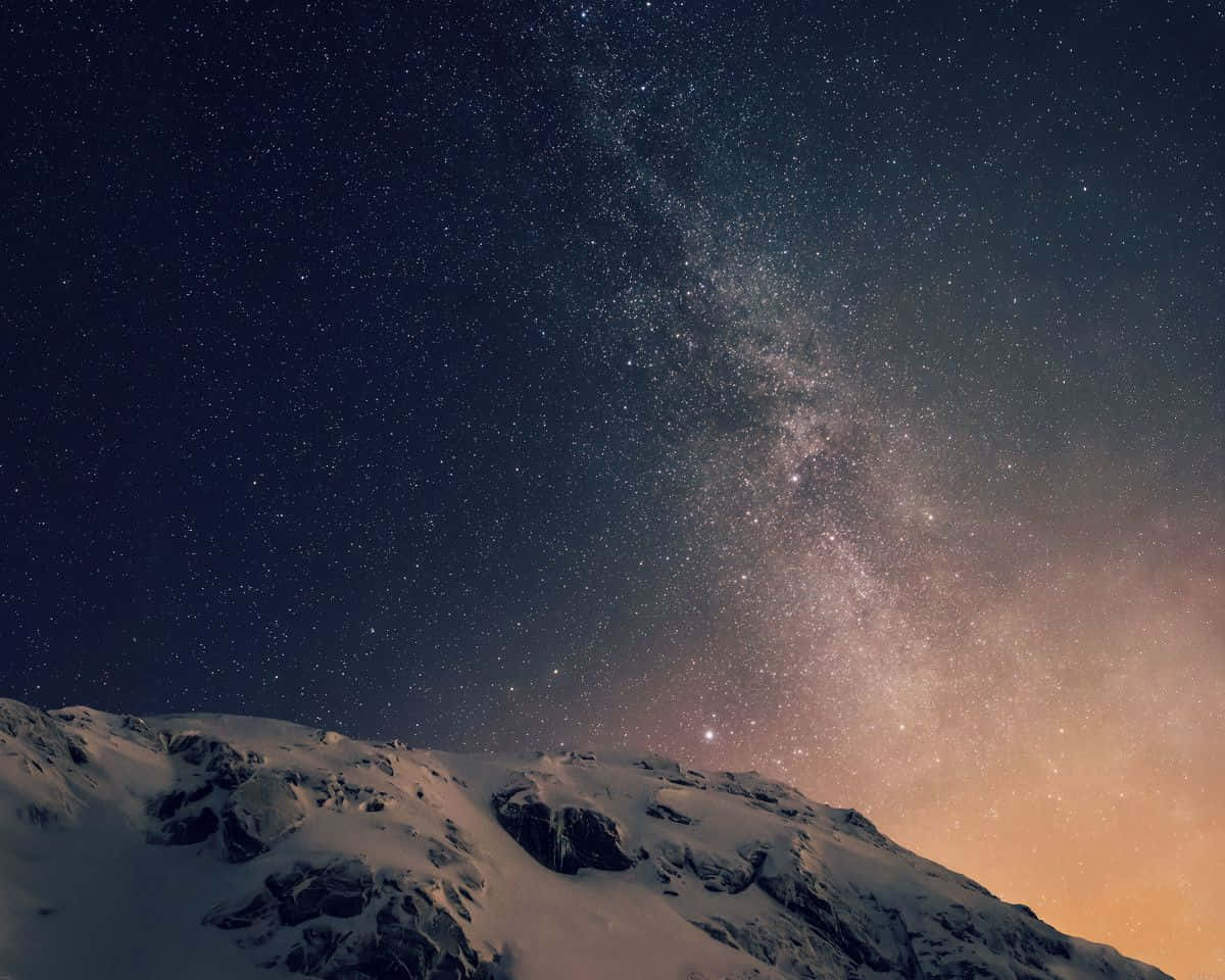 在繁星點點的夜空下，白雪覆蓋的山峰，銀河清晰可見。 — 圖片 GIF 壁紙