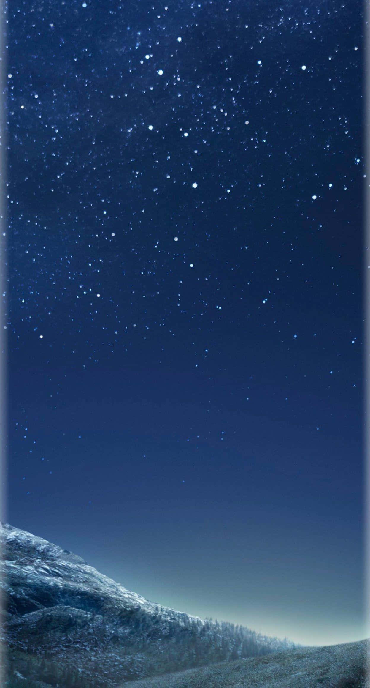 Galaxy S 桌布 壁紙 — 白雪覆蓋的山脊，在廣闊的星空下閃爍著深藍和白色的光芒。