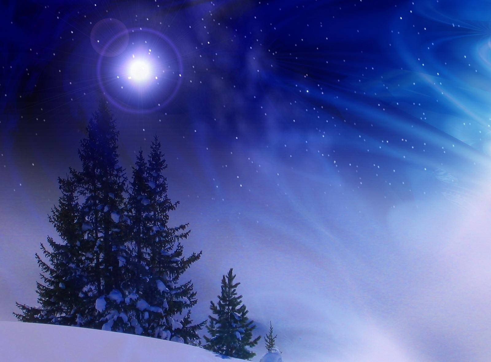 藍色 桌布 壁紙 — 白雪覆蓋的松樹在明亮的月亮和繁星點點的夜空下，伴隨著旋轉的藍色雲朵，形成剪影。