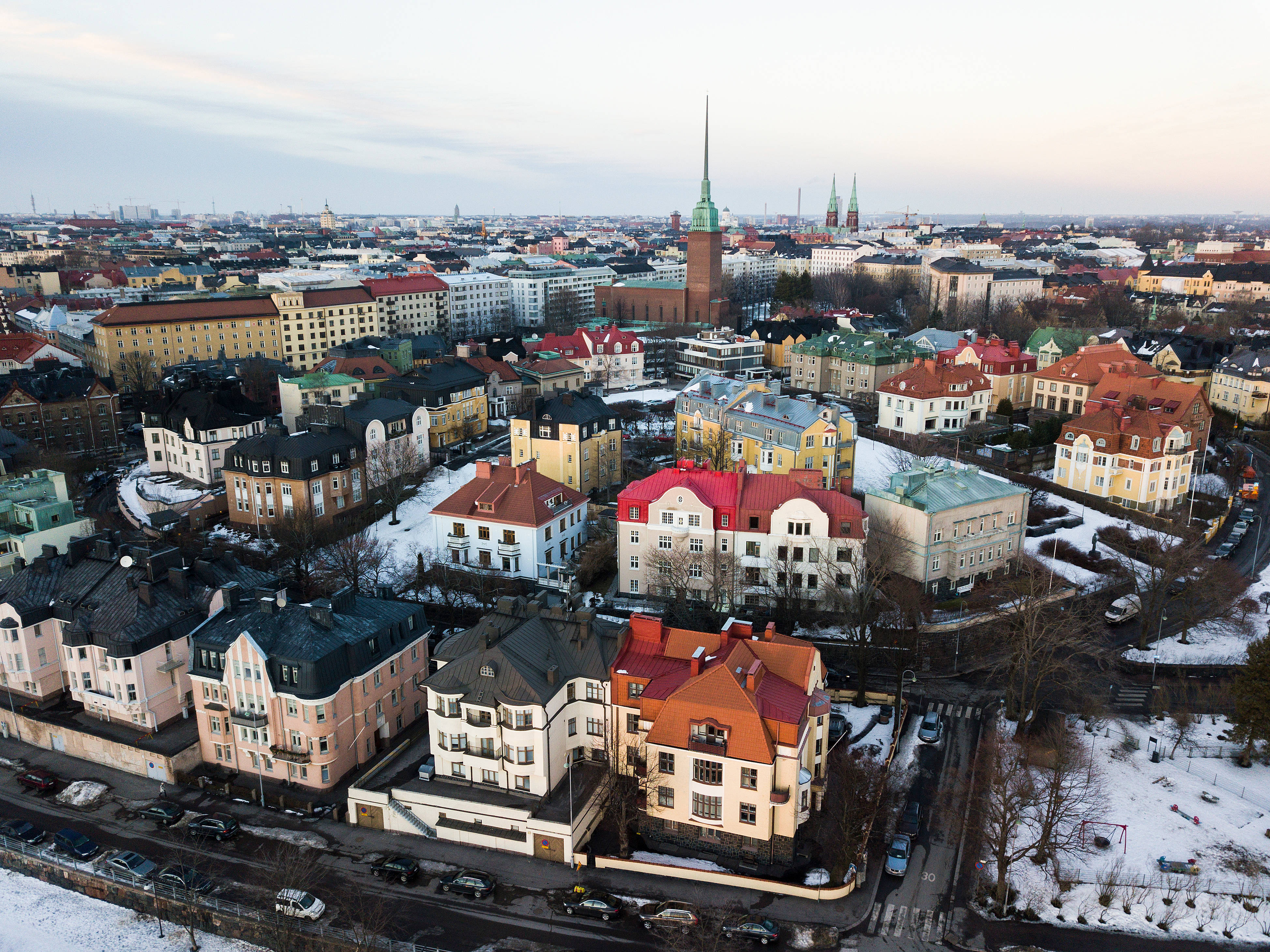 Finland 桌布 壁紙 — 白雪覆蓋的歐洲城市景觀鳥瞰圖，色彩繽紛的歷史建築和教堂尖塔在蒼白的冬日天空下。