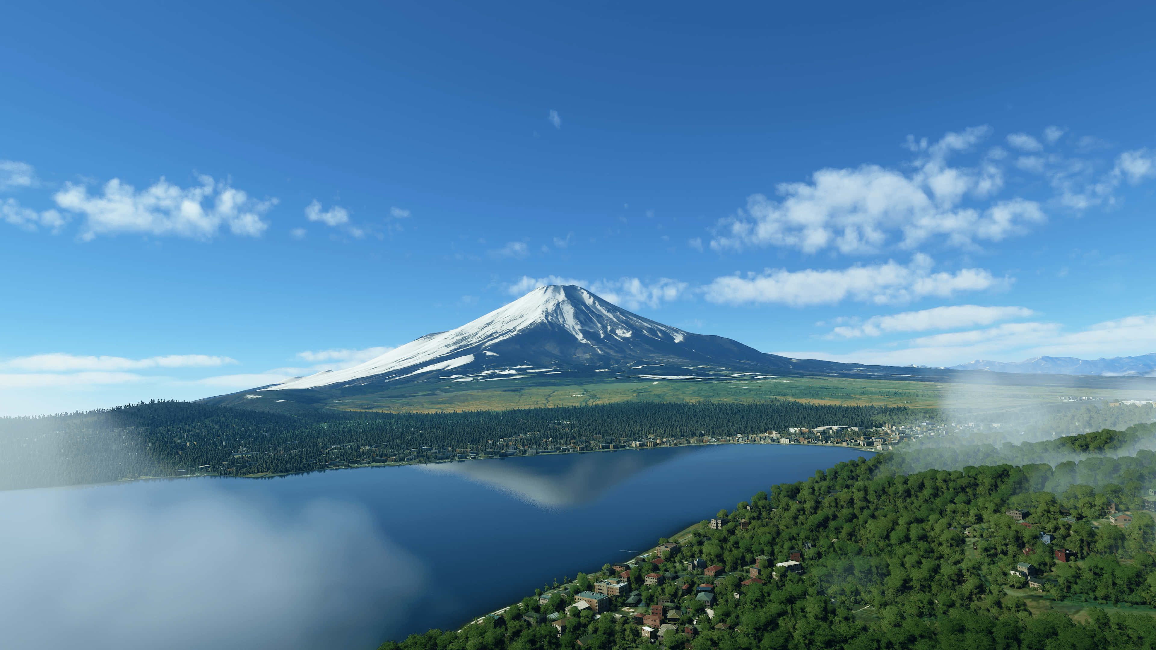 山景 桌布 壁紙 — 白雪覆蓋的沙斯塔山在平靜的湖泊後方雄偉地升起，湖岸迷濛，四周是茂密的綠色森林，上方是明亮的藍天。