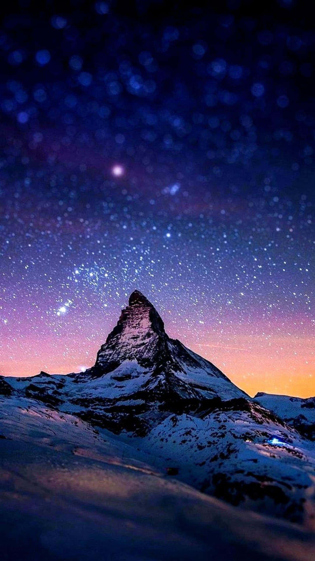 星空暮色下帶有紫色和橙色色調的雪山峰。 — 4K Android 壁紙