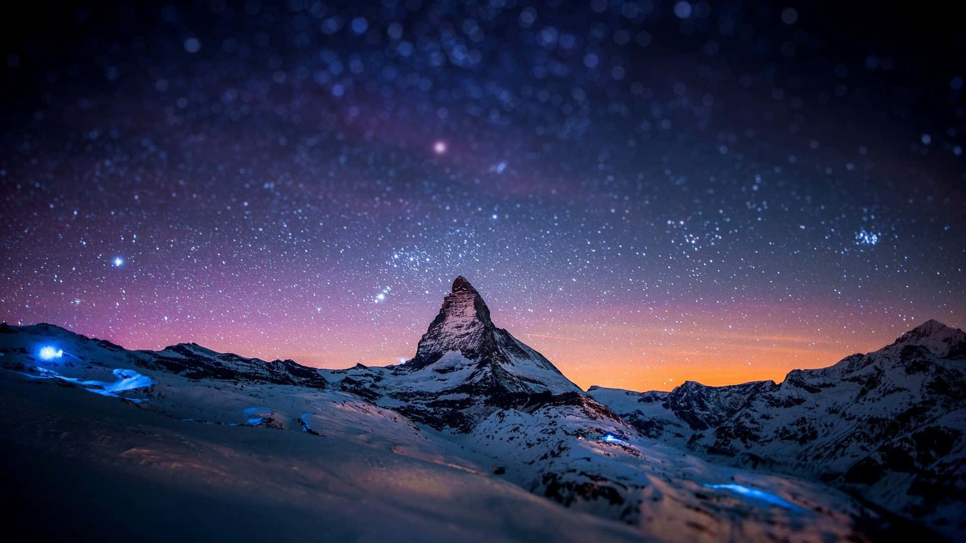 Mind-blowing 桌布 壁紙 — 白雪覆蓋的馬特洪峰在星空暮色下聳立，帶有紫橙漸變色和下方閃爍的藍光。