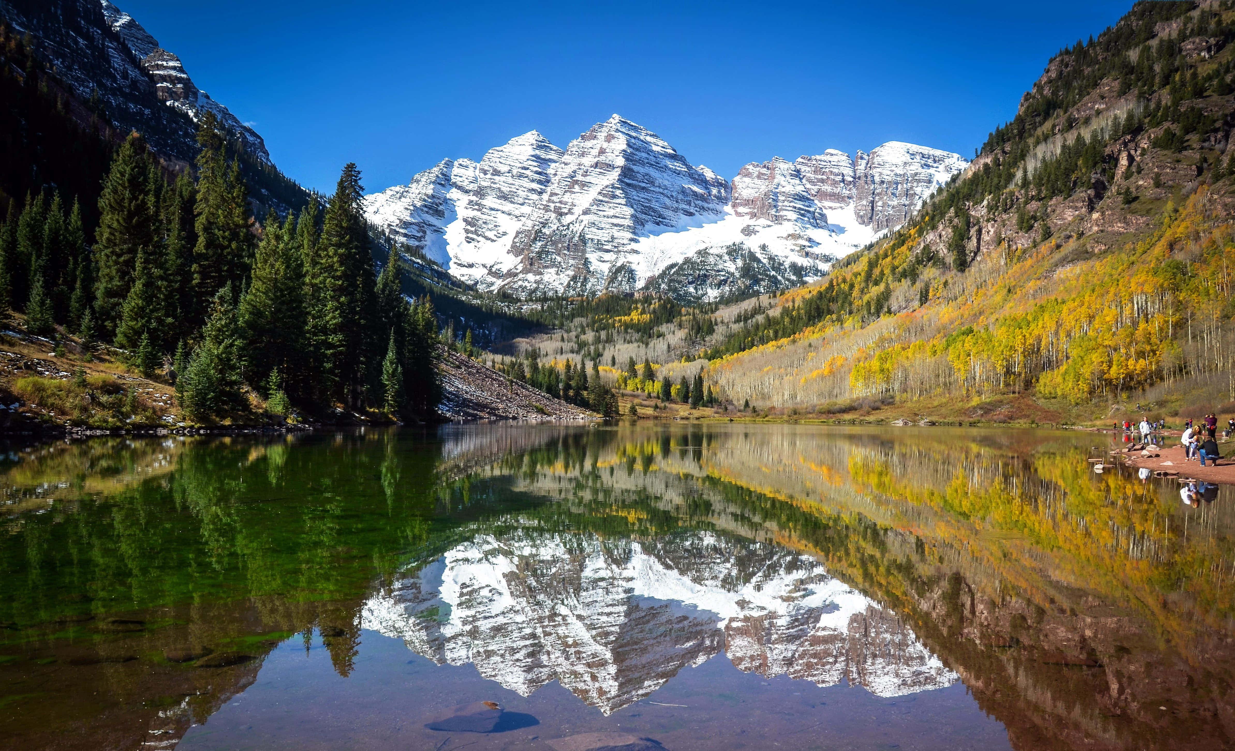 Aspen Colorado 桌布 壁紙 — 白雪覆蓋的馬龍峰在寧靜的高山湖泊中完美倒映，周圍環繞著秋日白楊和常青樹。