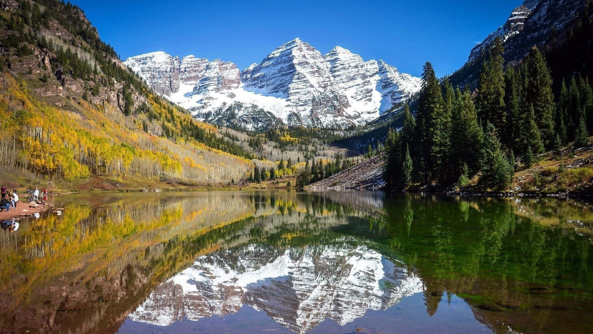 Colorado 桌布 壁紙 — 白雪覆蓋的馬龍峰在寧靜的高山湖泊中完美倒映，四周環繞著秋日白楊和常青樹。
