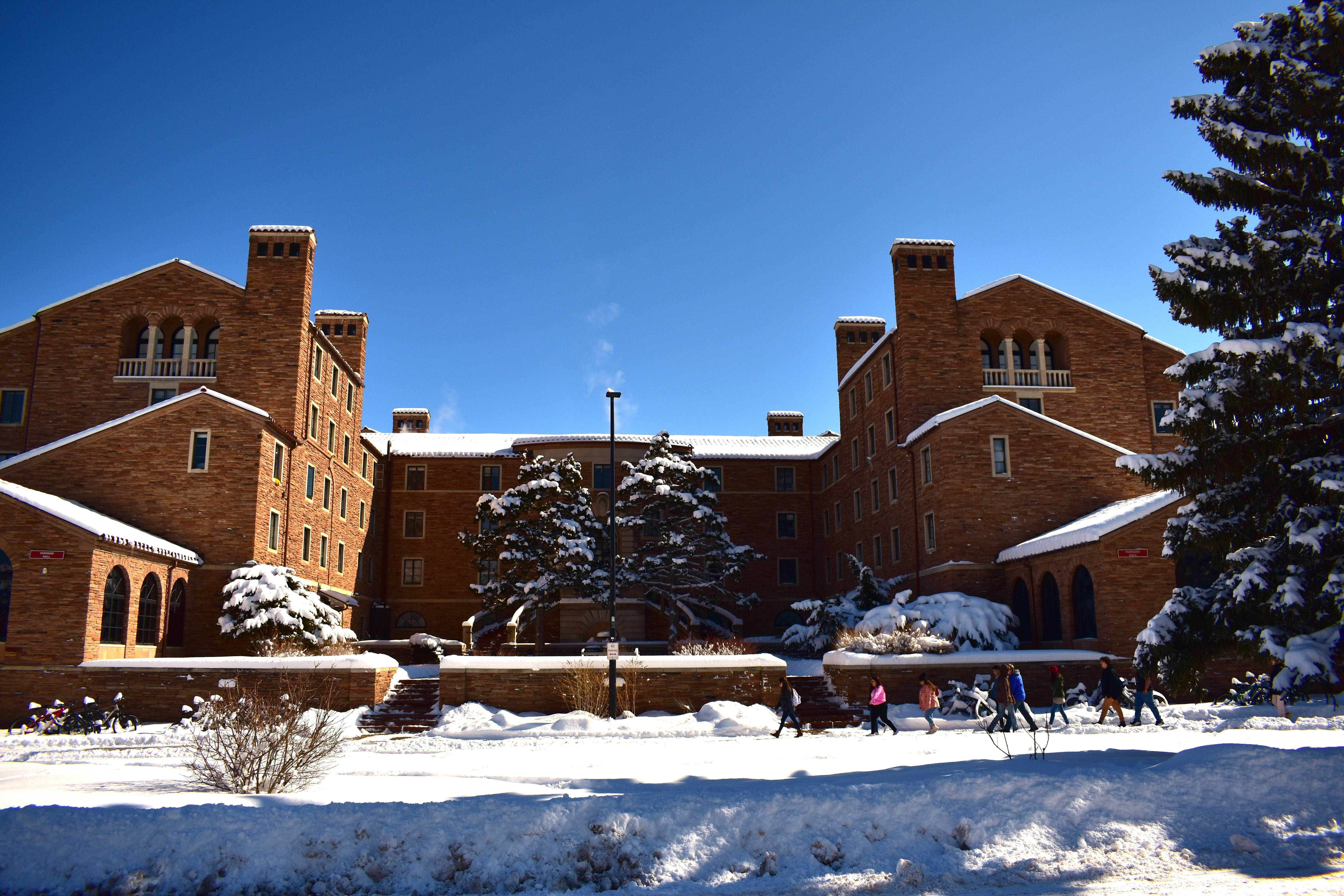 Colorado 桌布 壁紙 — 白雪覆蓋紅磚大學建築，學生在晴朗藍天下走過校園廣場。