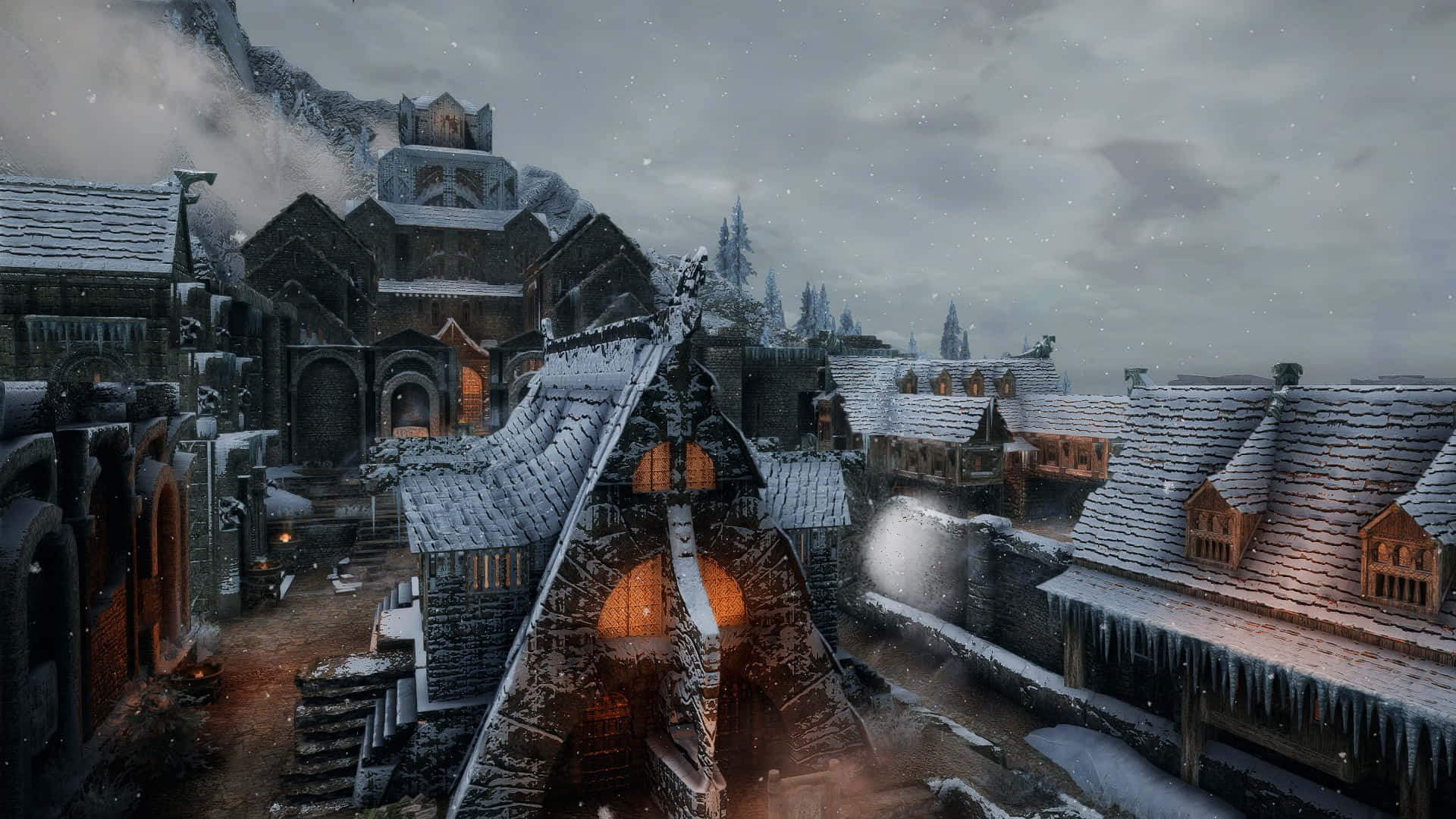 Skyrim Windhelm 桌布 壁紙 — 白雪覆蓋著一個中世紀村莊，冰封的屋頂和發光的窗戶在灰色的冬日天空下。