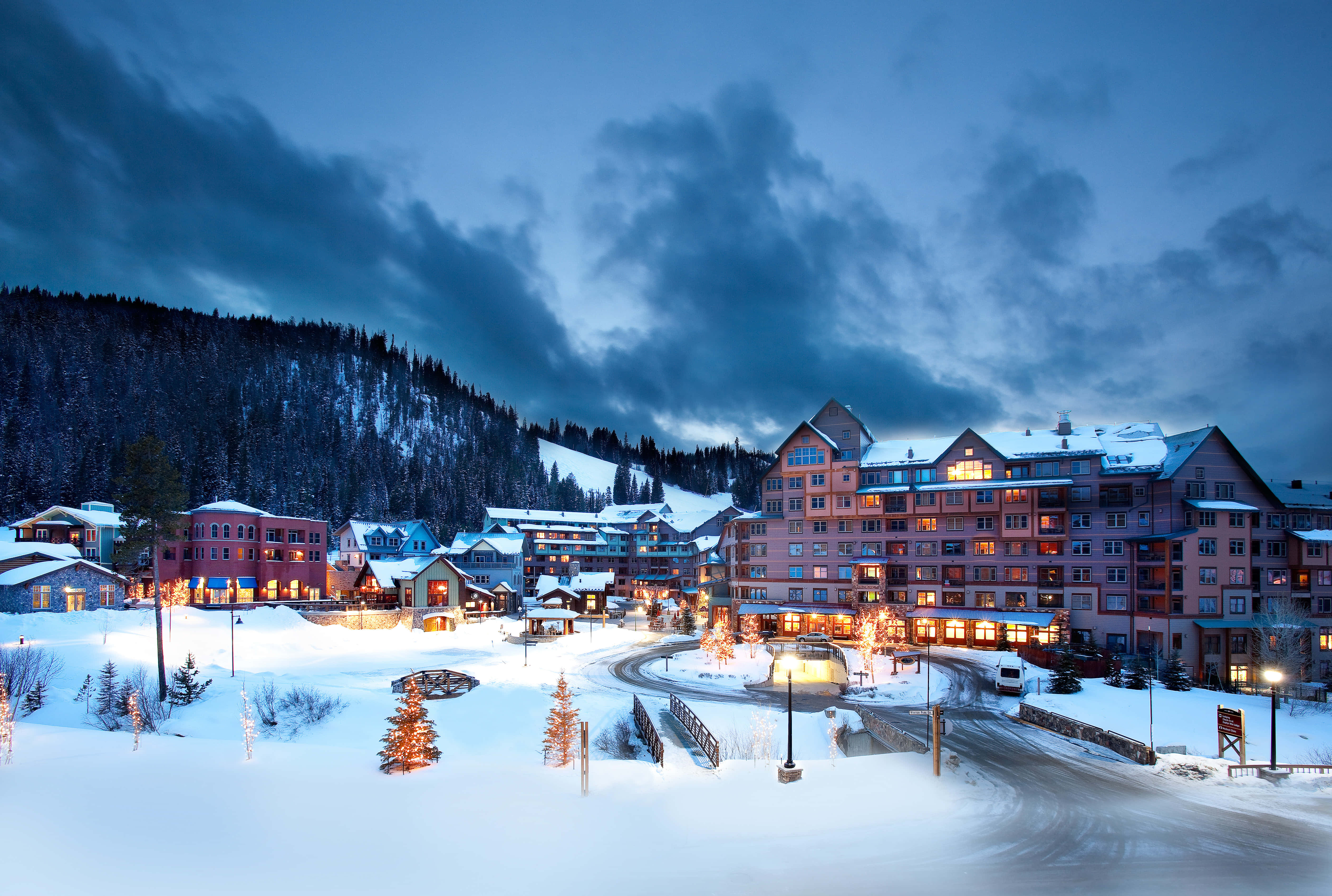 Aspen Colorado 桌布 壁紙 — 白雪覆蓋著舒適的山村，在暮色中，溫暖的燈光從窗戶透出，映襯著憂鬱的藍色天空。