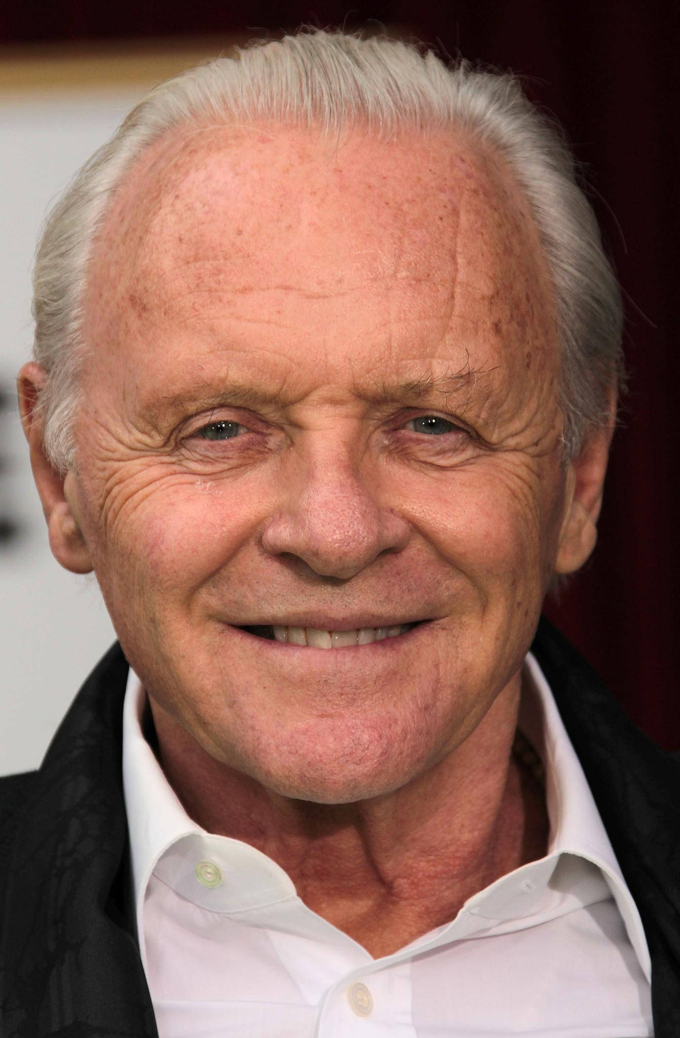 actor 桌布 壁紙 — 白髮長者身穿白襯衫和黑色外套，面露溫暖笑容的特寫肖像。