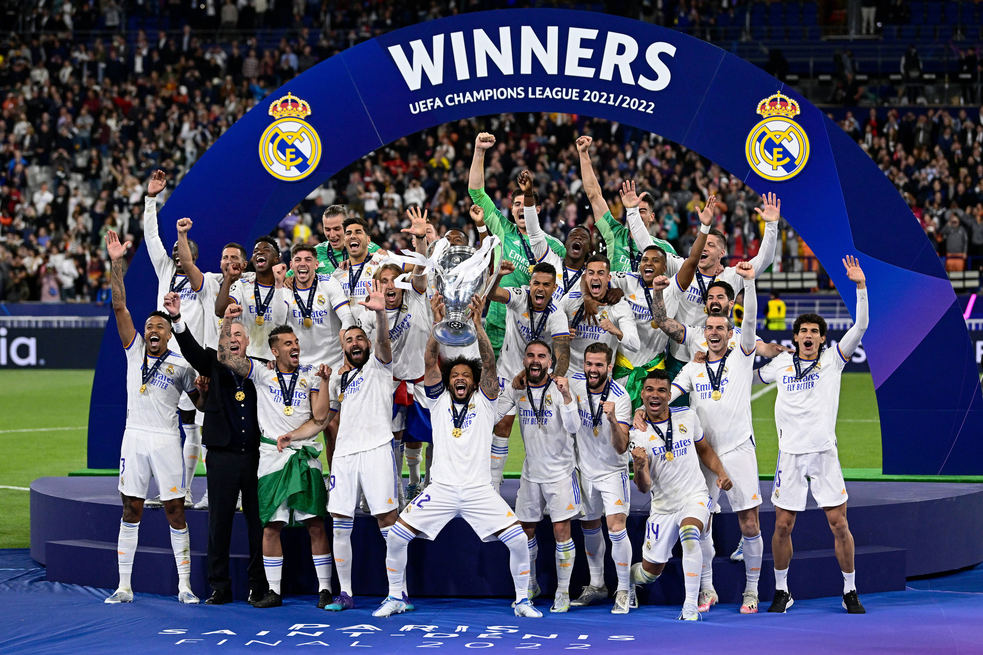 Real Madrid 4K 桌布 壁紙 — 皇家馬德里足球隊在球場燈光下高舉歐冠獎盃慶祝勝利。