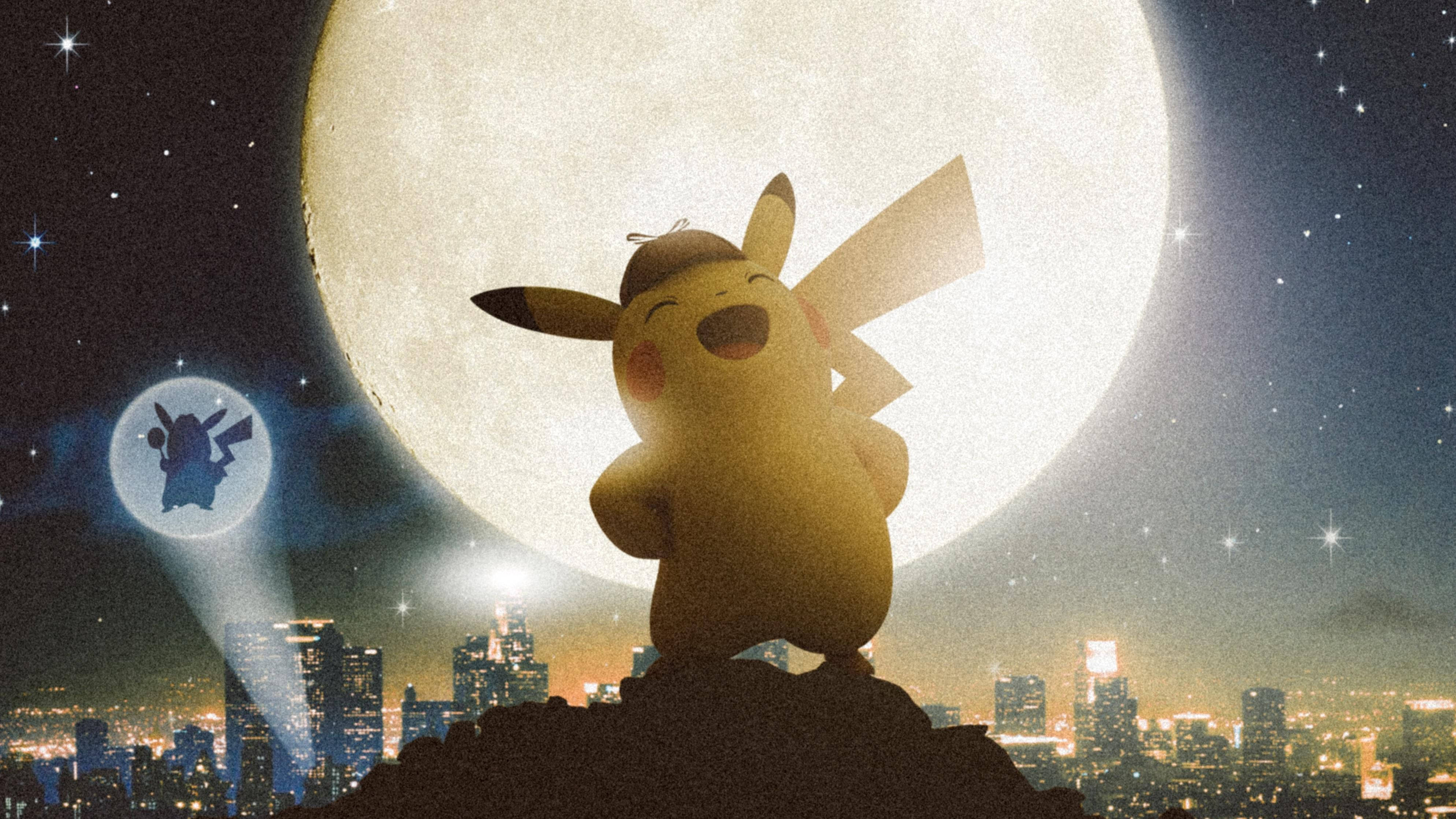 名偵探皮卡丘 桌布 壁紙 — 皮卡丘快樂地站在一個小山丘上，頭頂是一輪巨大的月亮，下方是閃爍的城市天際線，夜空中星星閃爍。