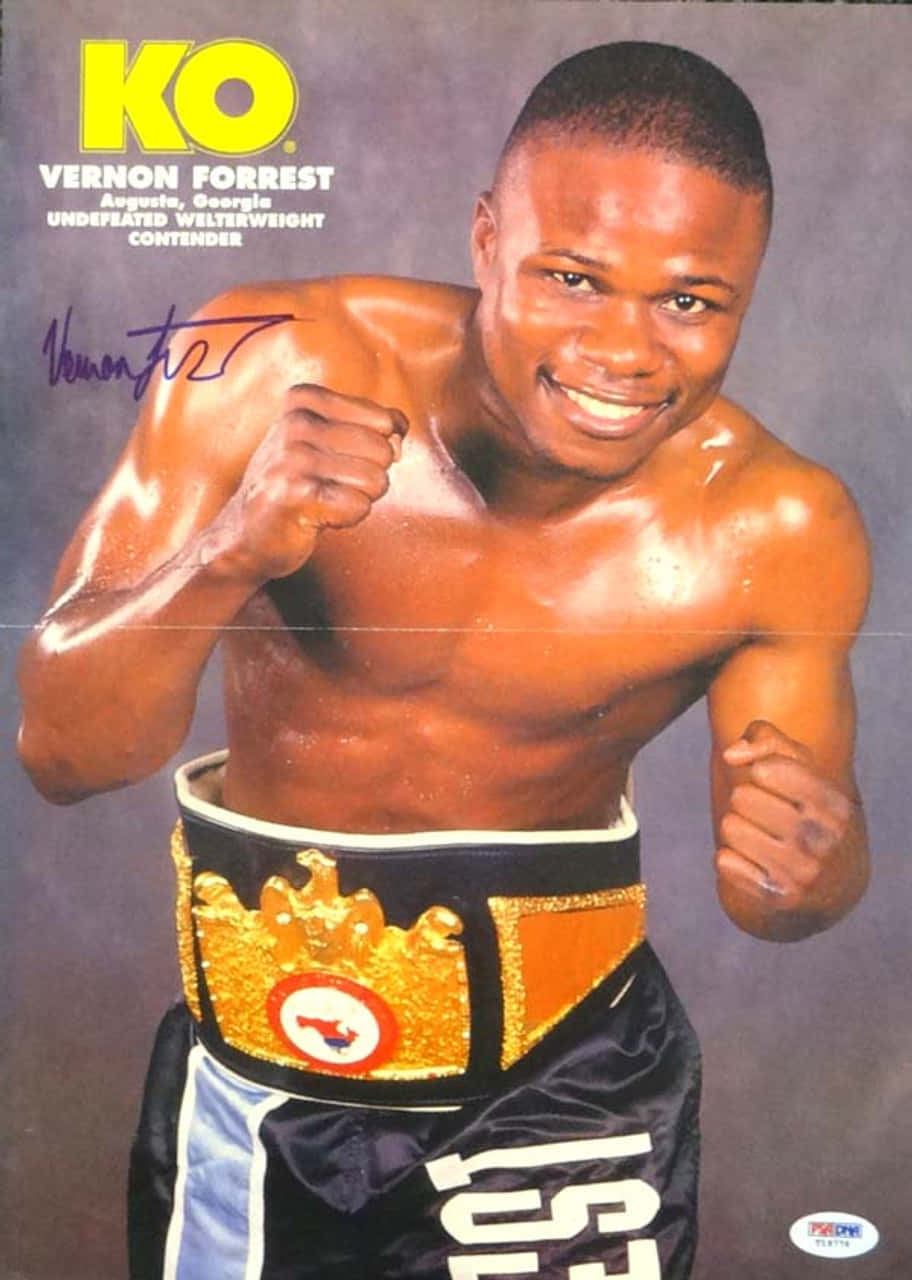 Boxing 桌布 壁紙 — 皮膚閃亮的拳擊手Vernon Forrest自信微笑，擺出戰鬥姿勢，腰間繫著冠軍腰帶，背景為灰色攝影棚。