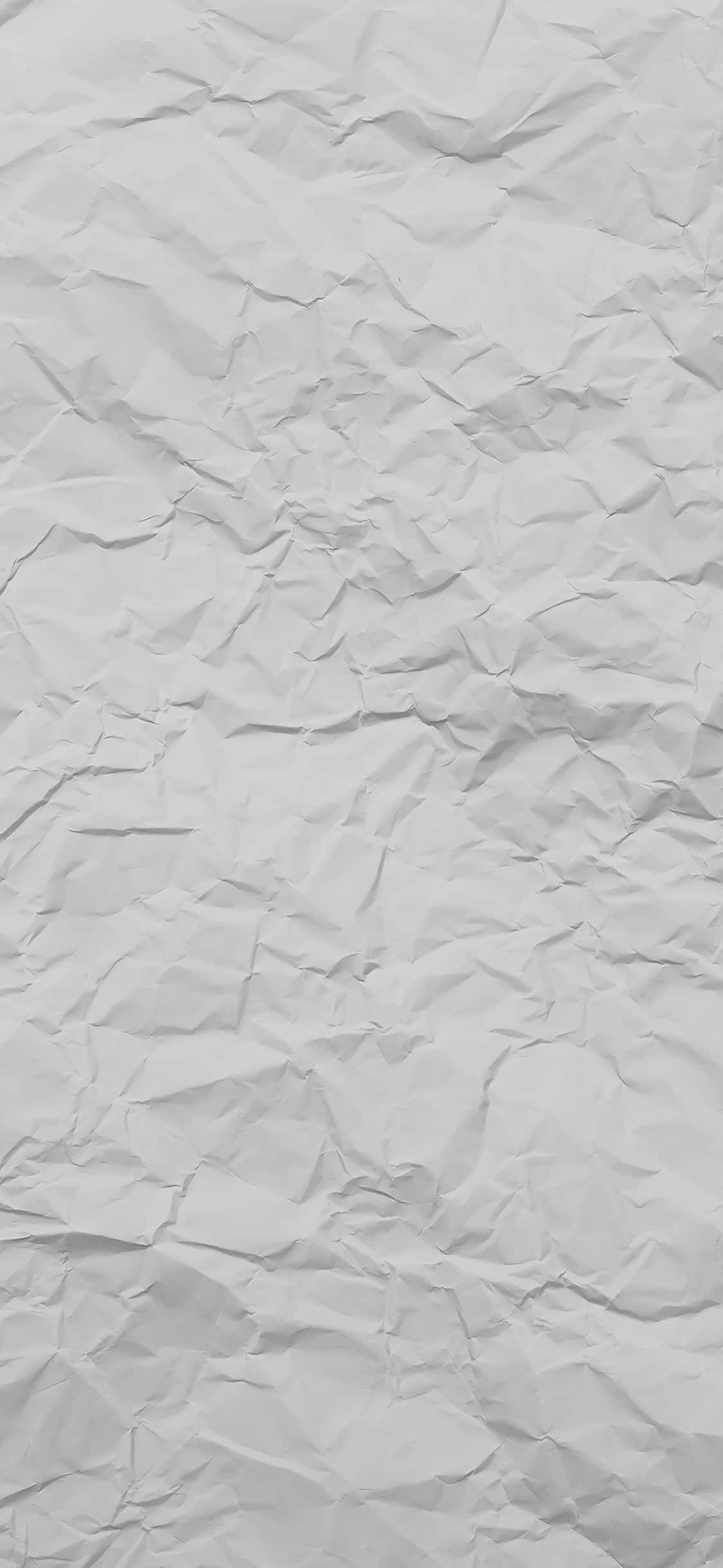 Light Gray iPhone 桌布 壁紙 — 皺巴巴白紙的特寫，柔和陰影突出其紋理摺痕和皺褶。