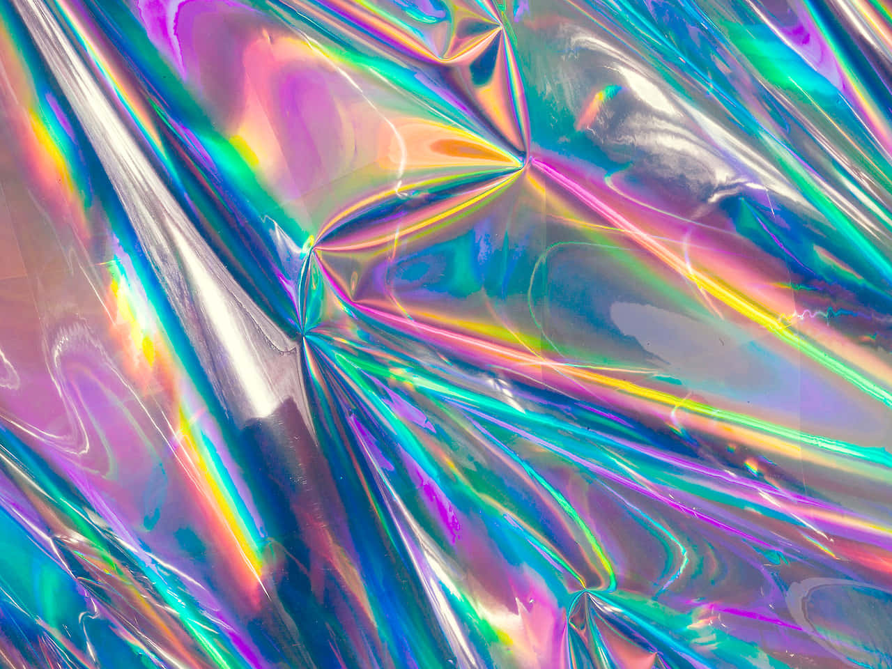 全息 桌布 壁紙 — 皺巴巴的全息箔特寫，在動態摺痕中反射出鮮豔的彩虹色調。