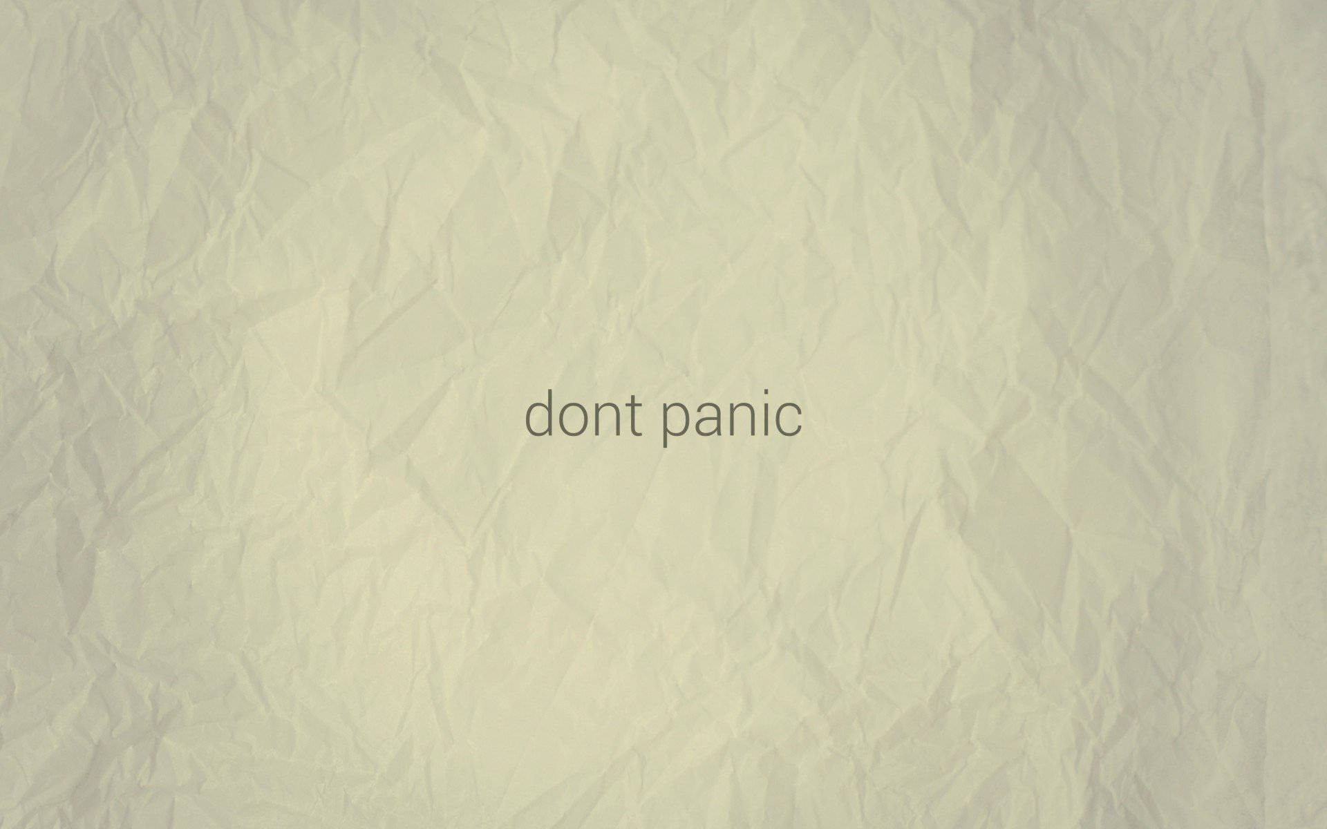 恐慌 桌布 壁紙 — 皺巴巴的淺綠色紙張，中央以柔和灰色顯示 dont panic 文字。