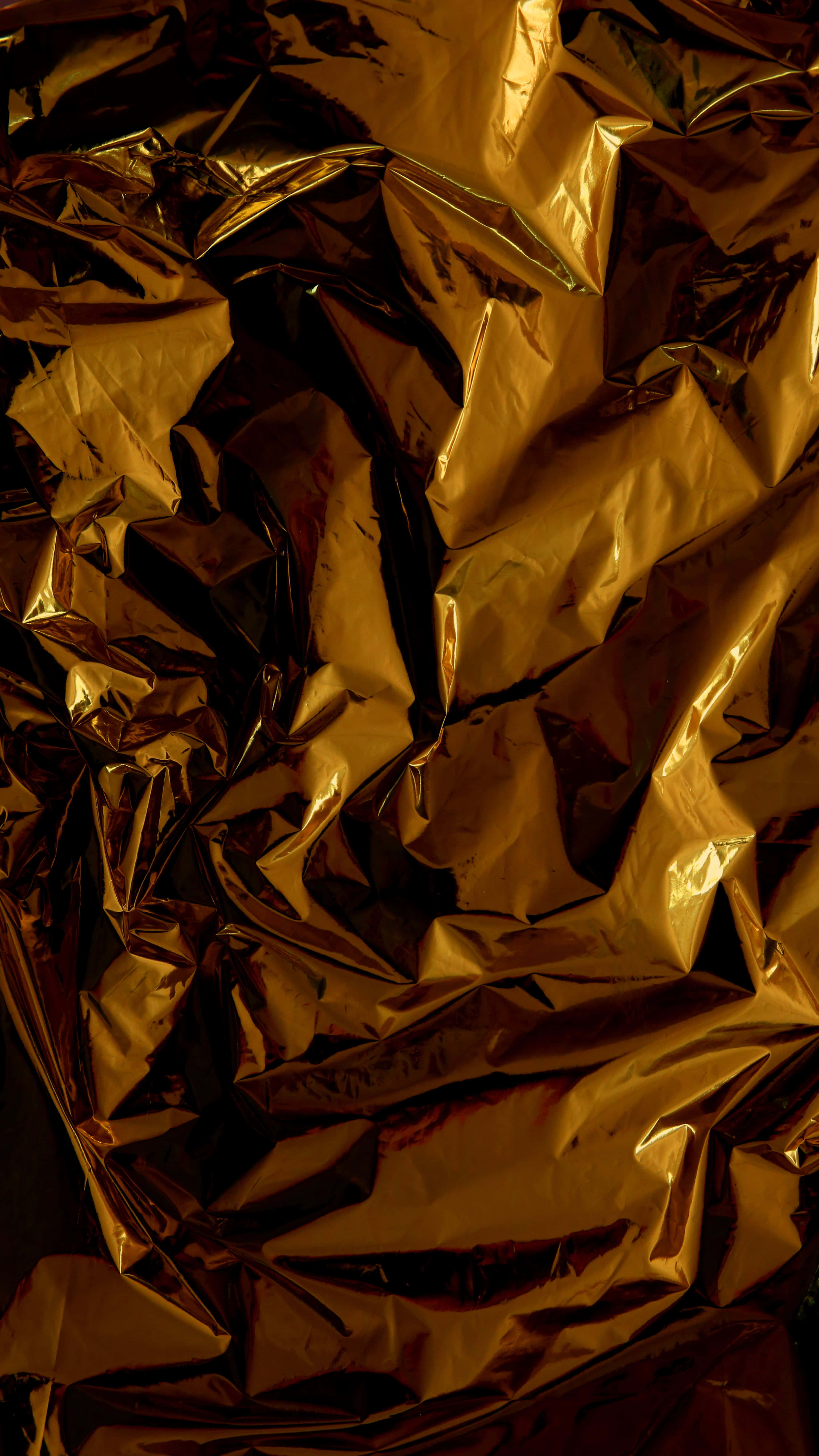 Shiny Gold 桌布 壁紙 — 皺巴巴的金箔特寫，帶有深邃陰影和明亮高光，營造出奢華的紋理表面。