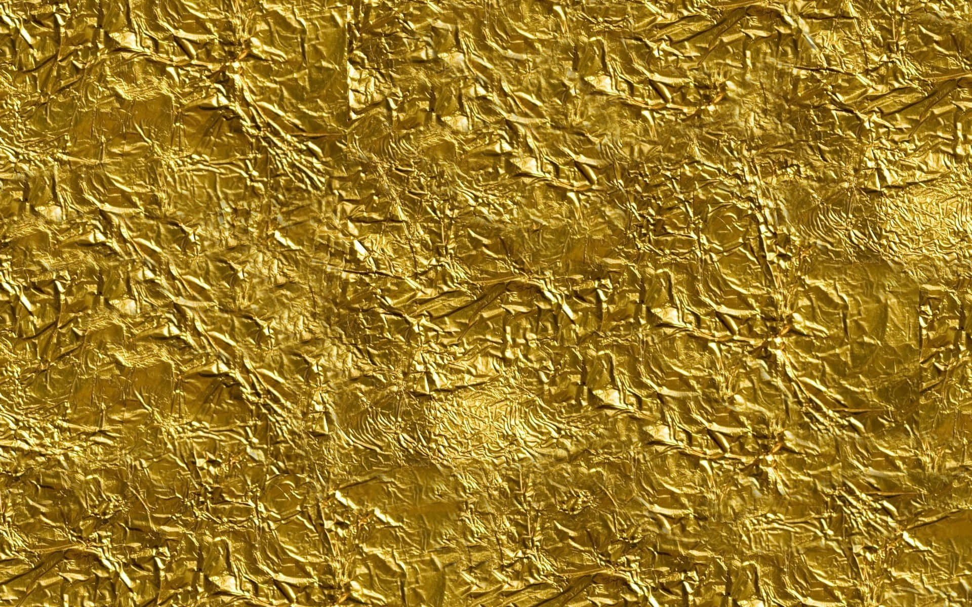 Gold Foil 桌布 壁紙 — 皺巴巴的金箔特寫，帶有複雜的摺痕和反射亮點。