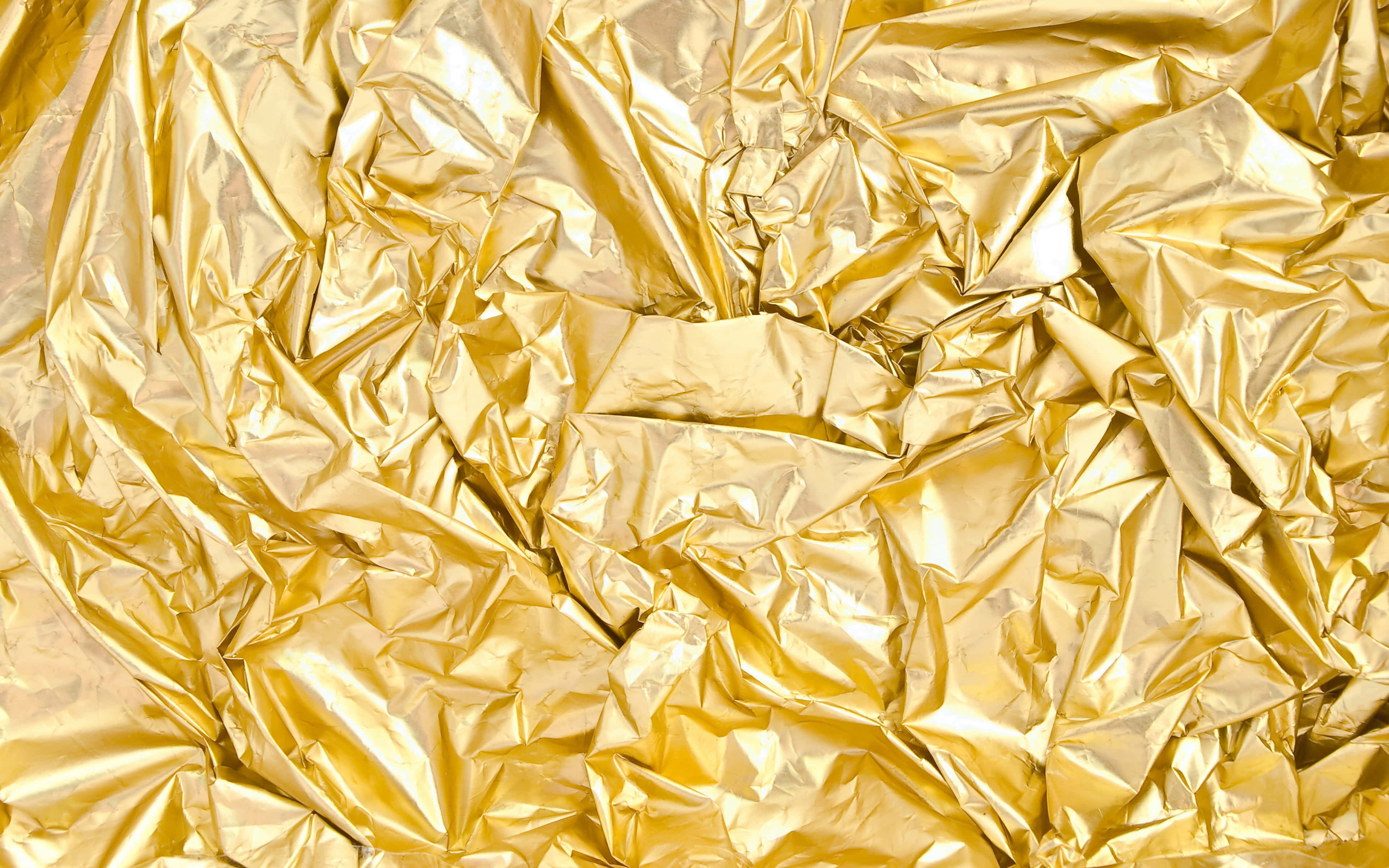 Foil 桌布 壁紙 — 皺巴巴的金箔特寫，帶有銳利的摺痕和反射亮點，營造出奢華的紋理表面。