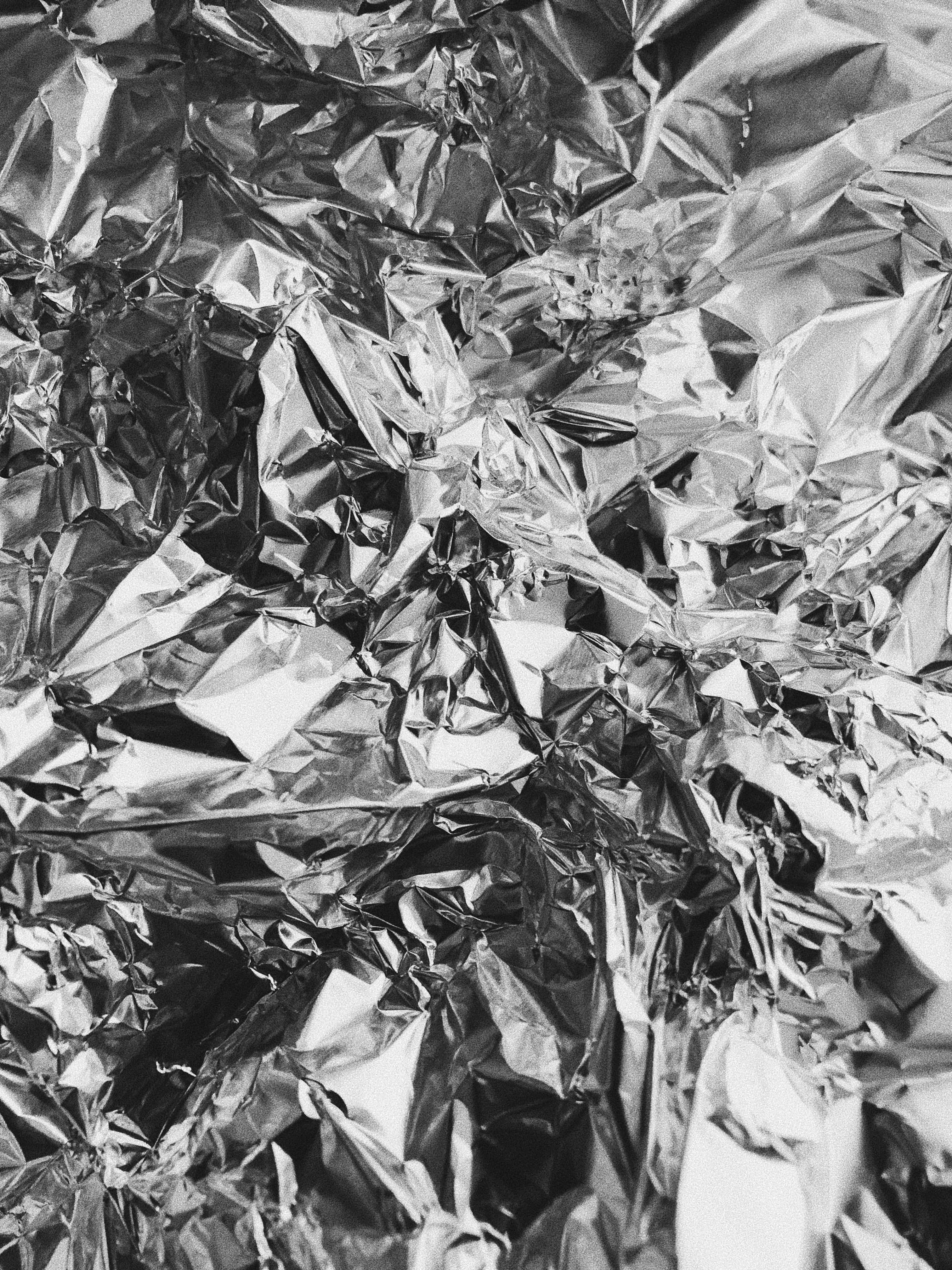 Foil 桌布 壁紙 — 皺巴巴的鋁箔紙特寫，帶有銳利的金屬高光和深色陰影，營造出紋理抽象的質感表面。