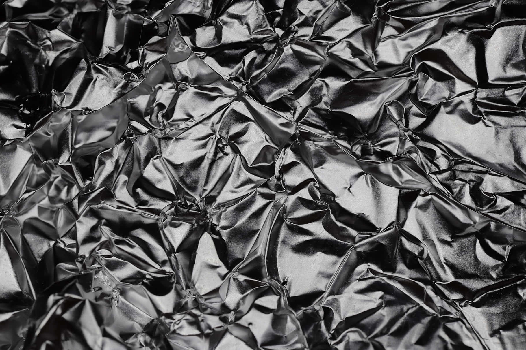 Black And White Texture 桌布 壁紙 — 皺巴巴的黑色金屬箔特寫，帶有銳利的摺痕和反光高光。