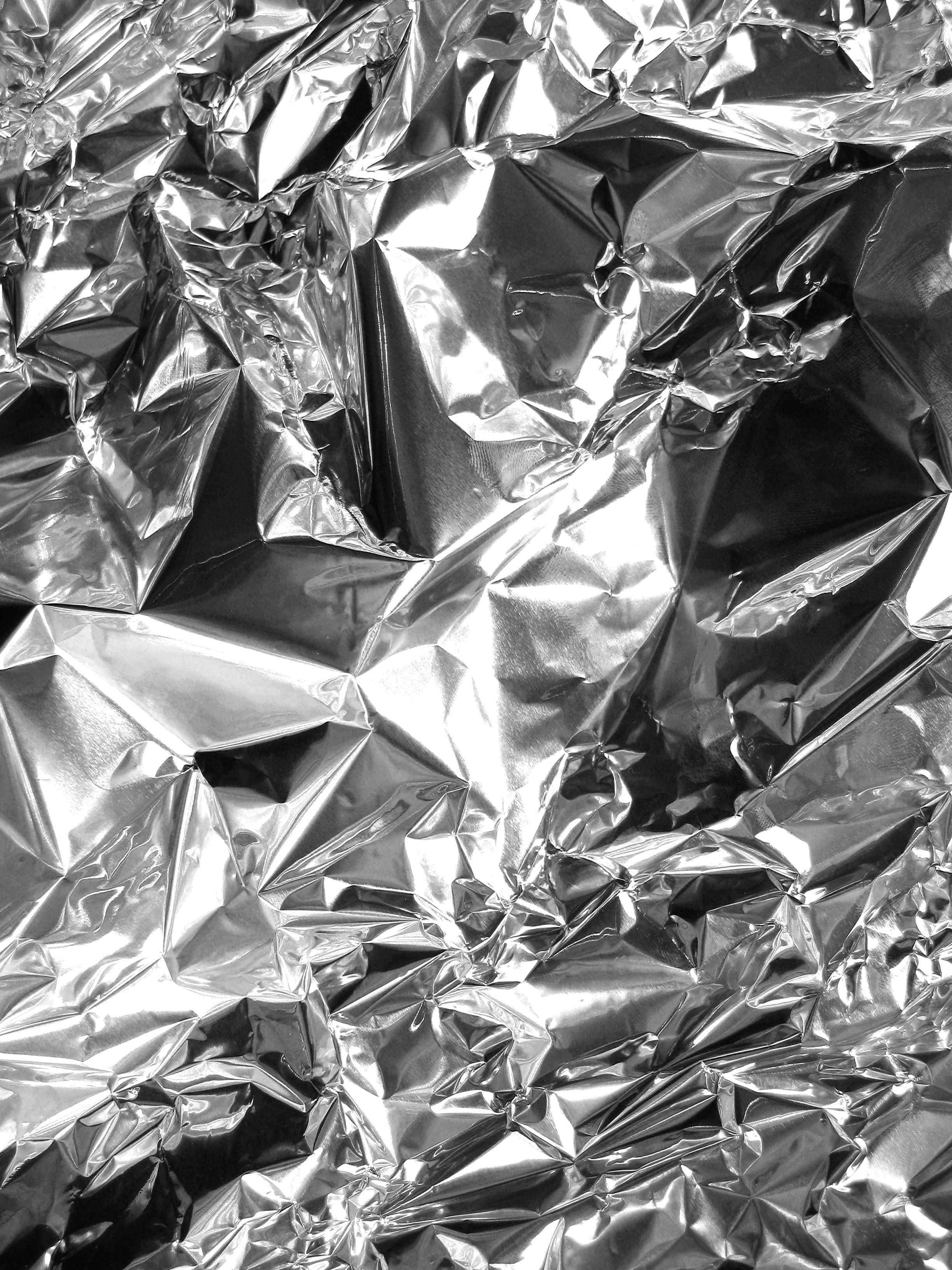 Silver Foil 桌布 壁紙 — 皺巴巴銀箔的特寫，帶有銳利的高光和深邃的陰影，營造出紋理金屬表面。