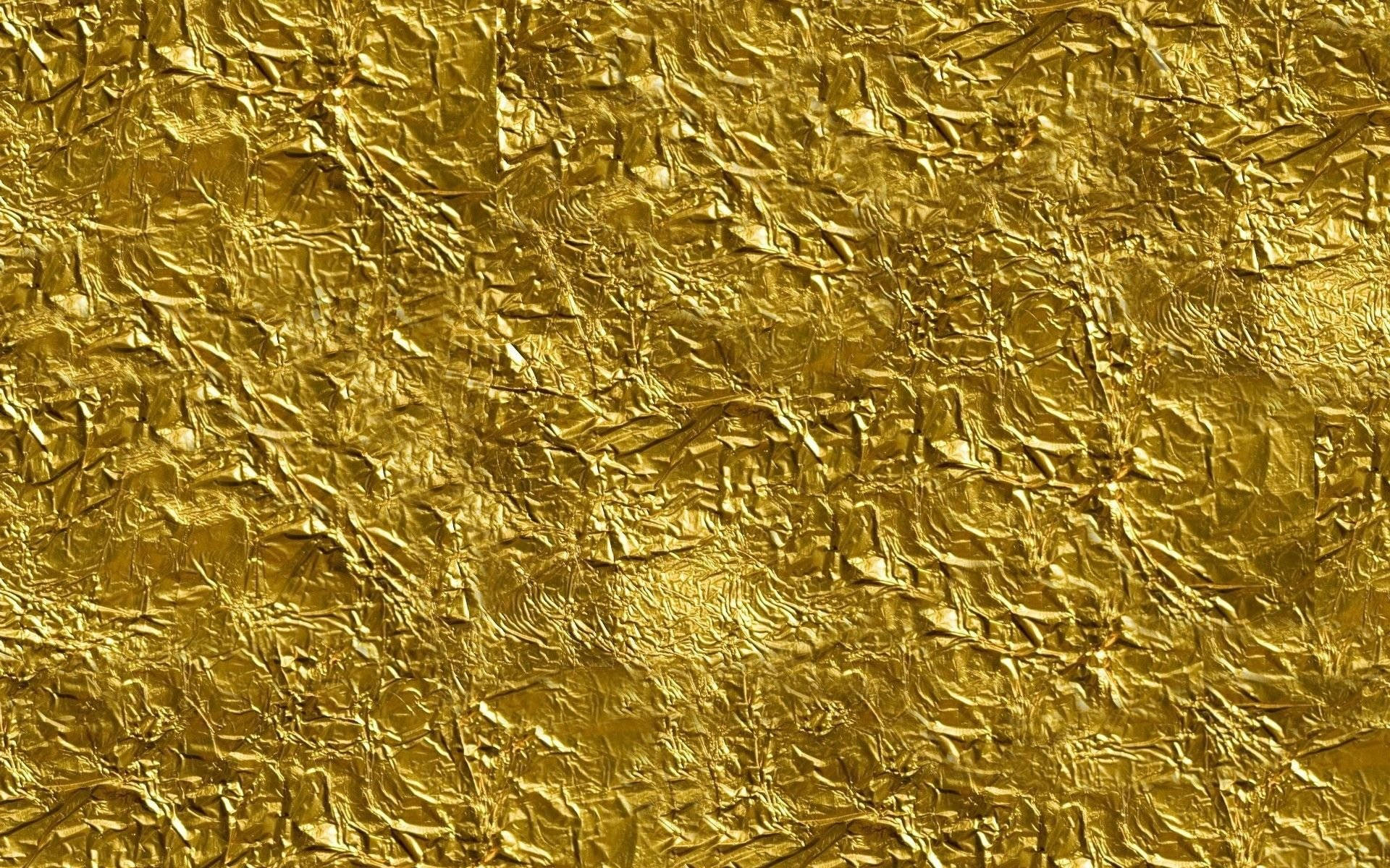 Foil 桌布 壁紙 — 皺紋金箔的特寫，帶有複雜的摺痕和反射光線的高光。