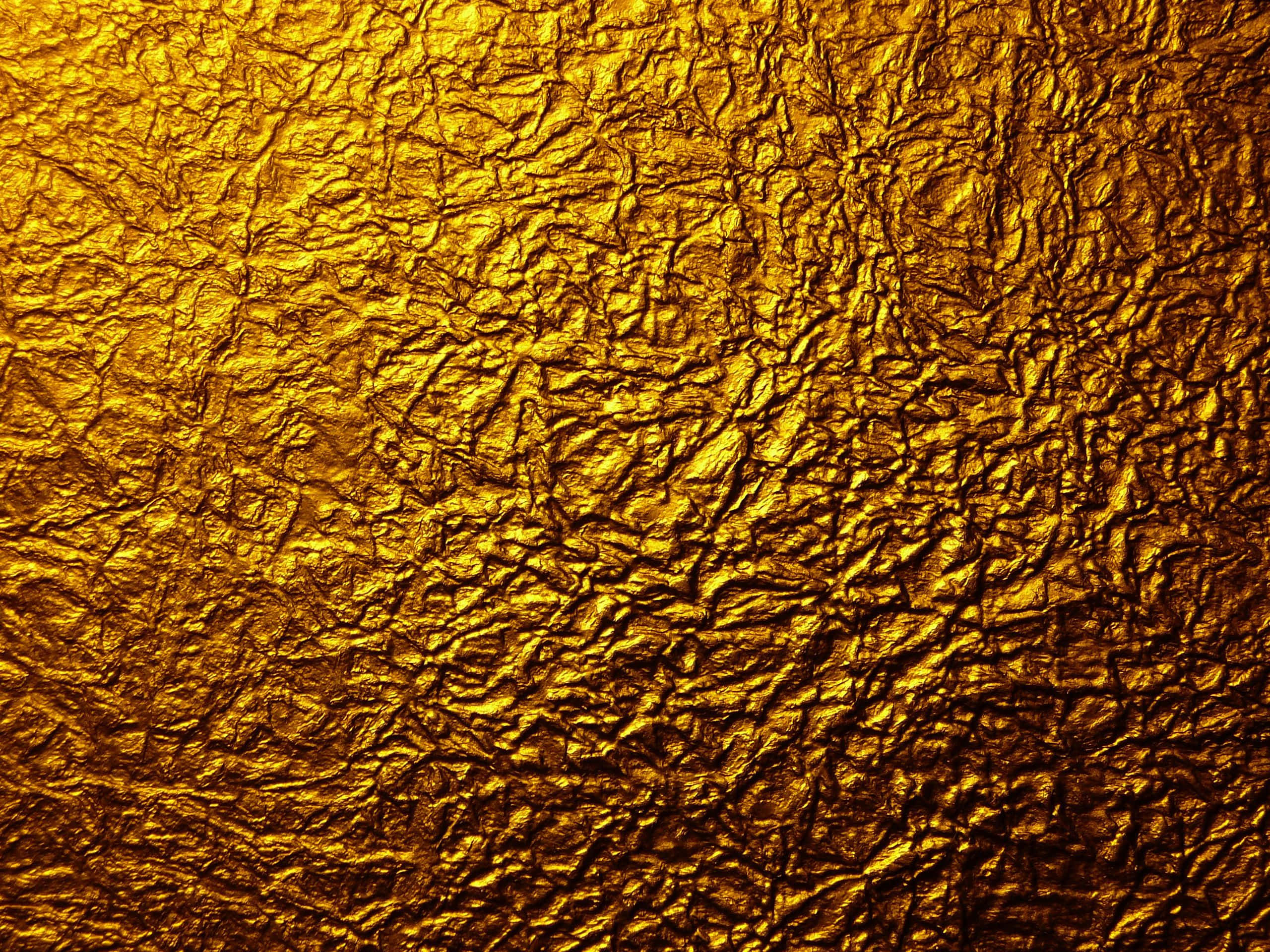 Metallic Gold 桌布 壁紙 — 皺紋金箔的特寫，豐富的高光和深邃陰影營造出奢華的紋理表面。